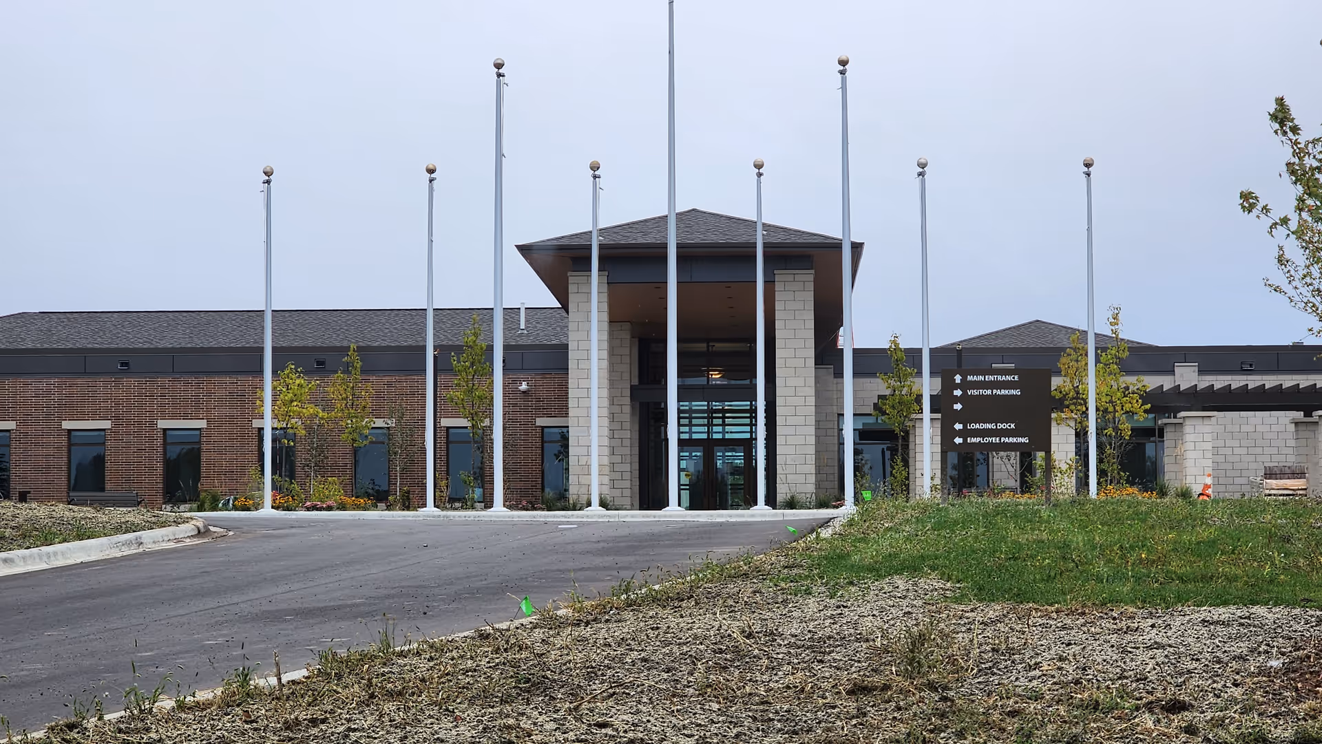 Exterior view of Minnesota Veterans Home entrance with flagpoles and glass doors