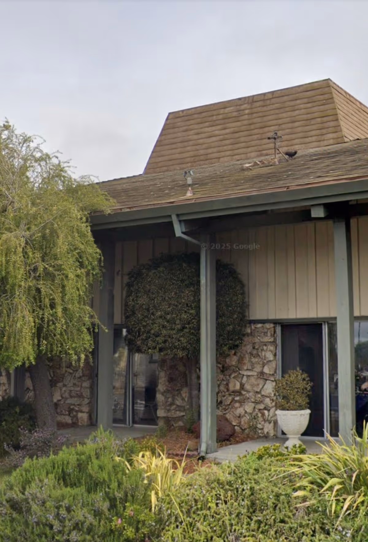 Front entrance of San Pablo Healthcare & Wellness Center with stone facade and landscaping.