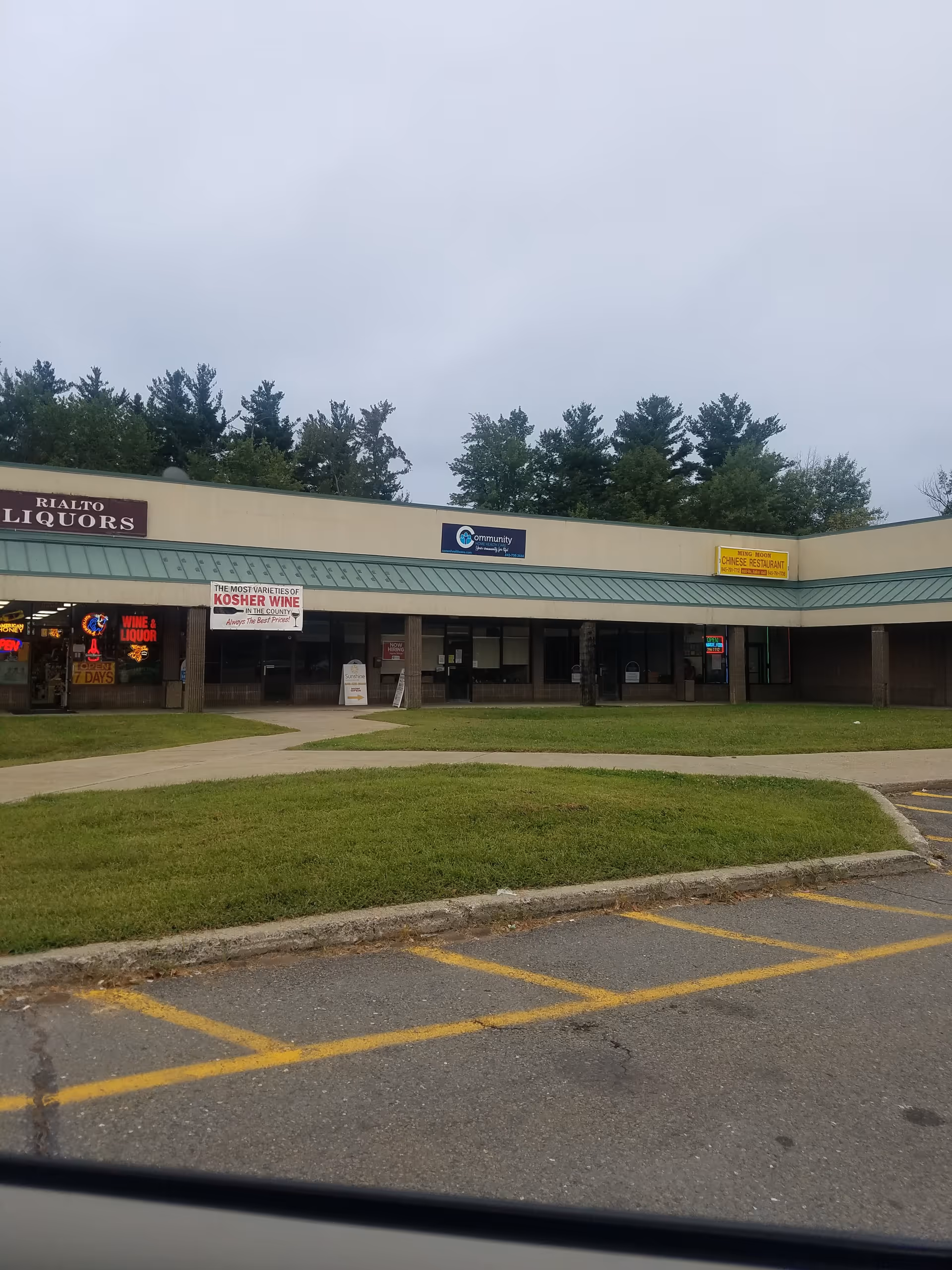 Exterior view of a strip mall with storefronts including a recruiting office sign.
