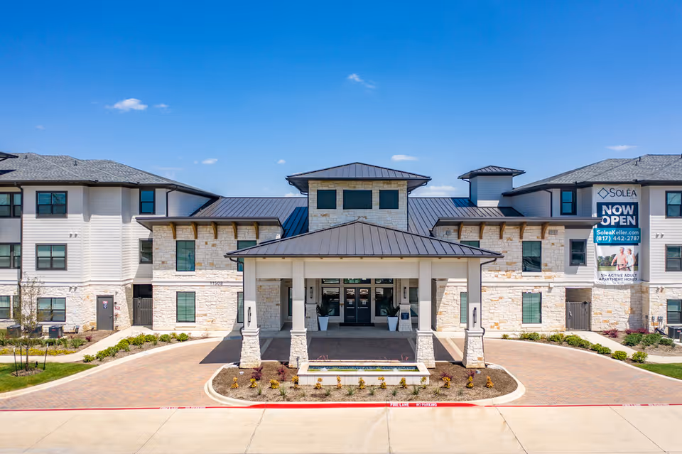 Exterior view of Solea Keller senior living center with covered entrance and signage.