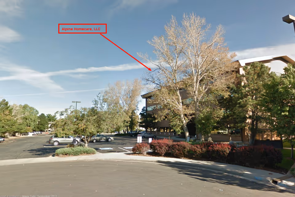 Exterior view of Alpine Homecare, LLC building with parking lot and trees.