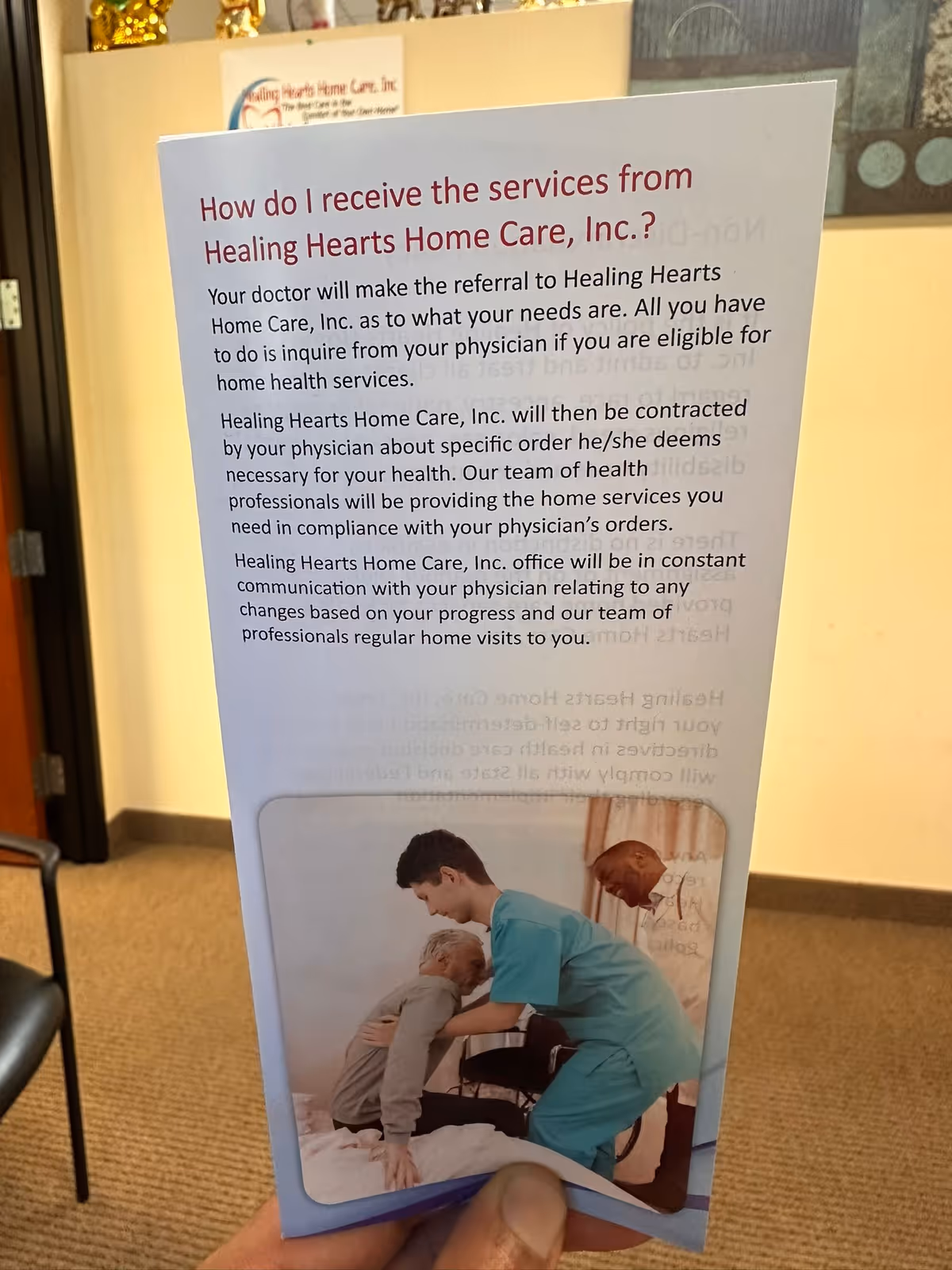 Indoor banner for Healing Hearts Home Care with a caregiver assisting an elderly person.