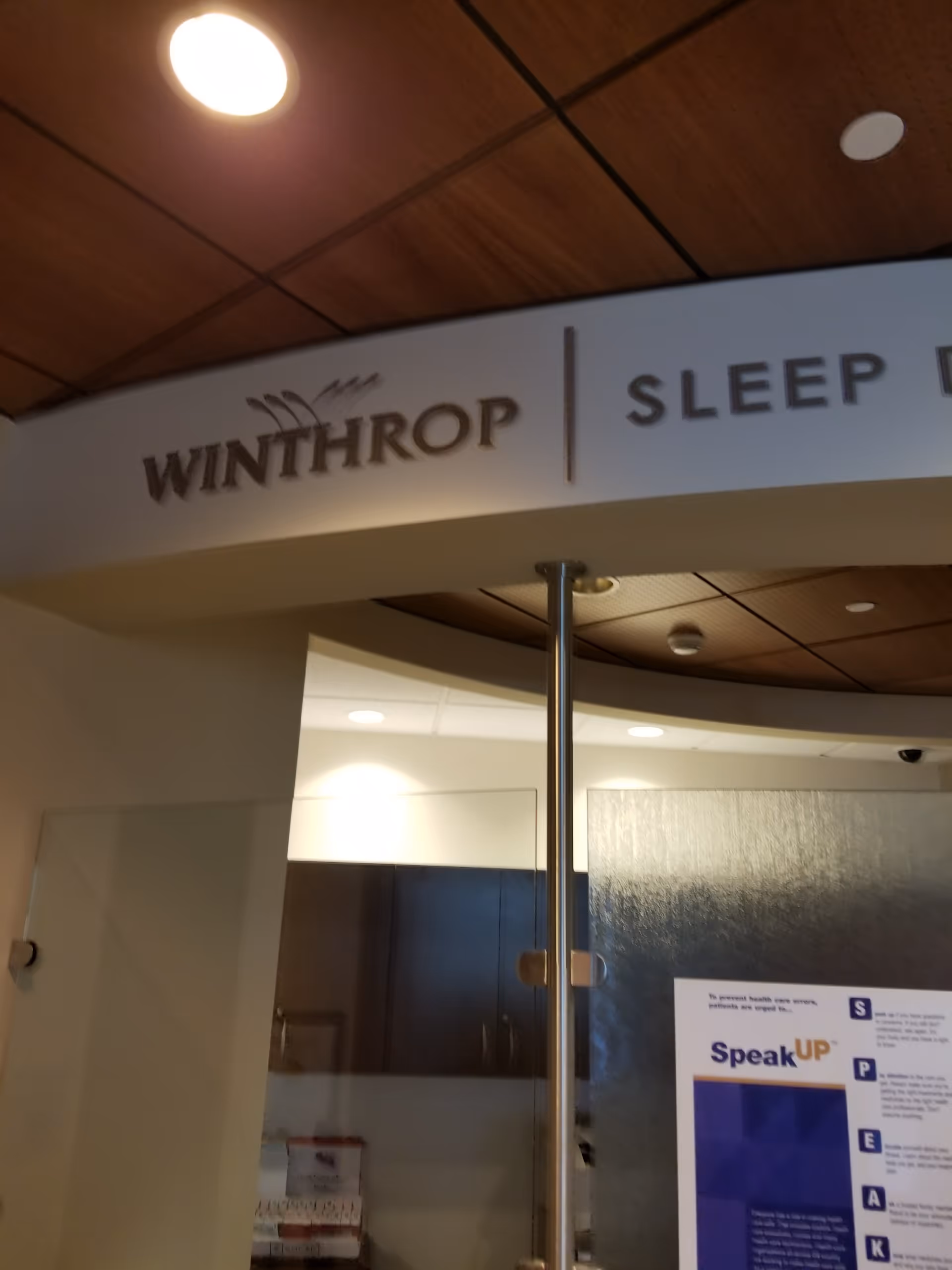 Curved sign reads Winthrop Sleep Medicine; interior lobby area with cabinets and a pole.
