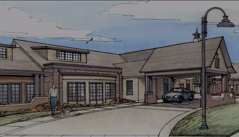 Illustration of the front exterior of a single-story building with a covered driveway entrance. A man is walking a dog on the sidewalk in front of the building. There is a car parked under the covered entrance and a streetlamp on the right side. The sky is partly cloudy.