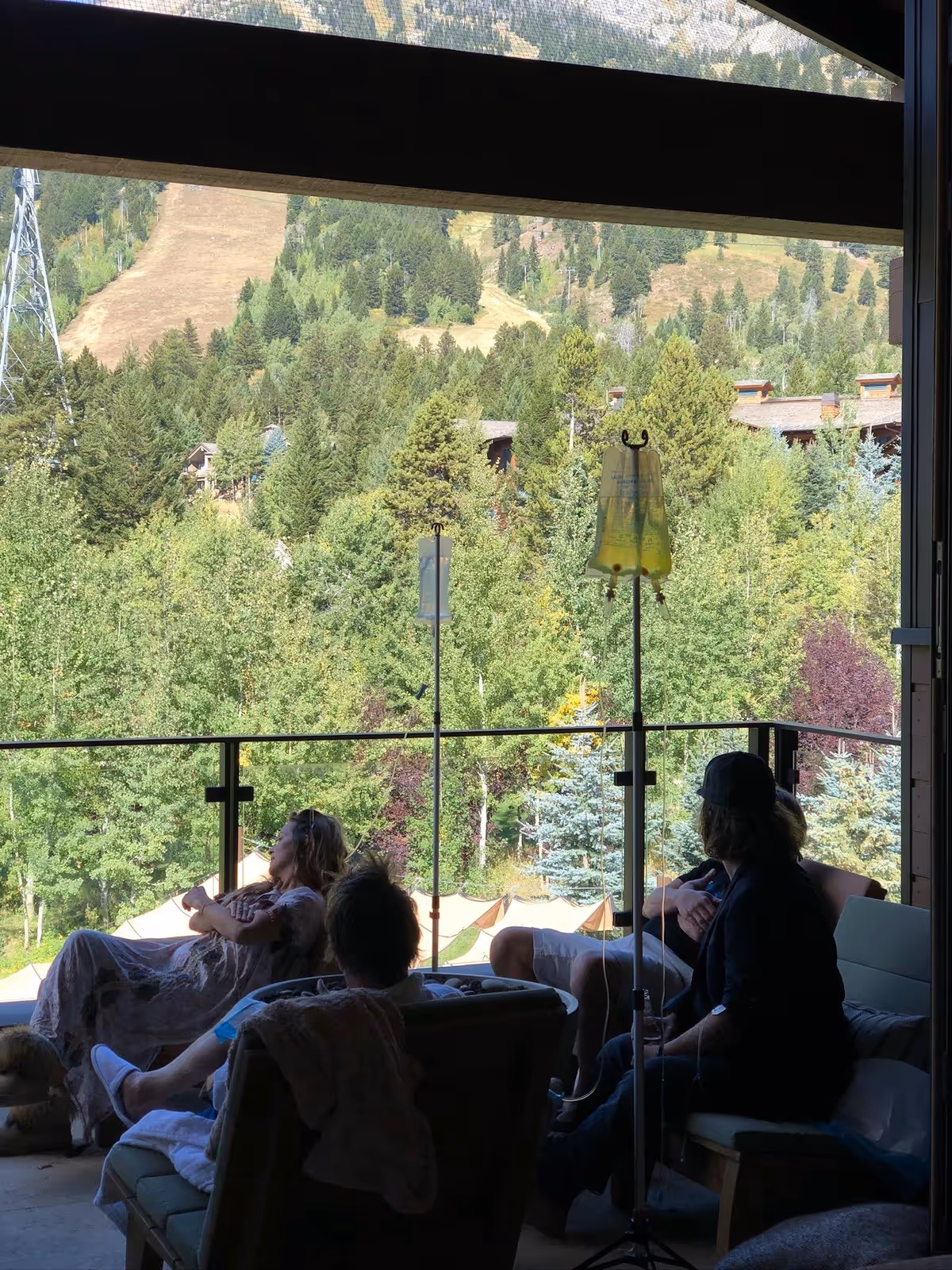 Residents lounge on an outdoor balcony with scenic mountain views.