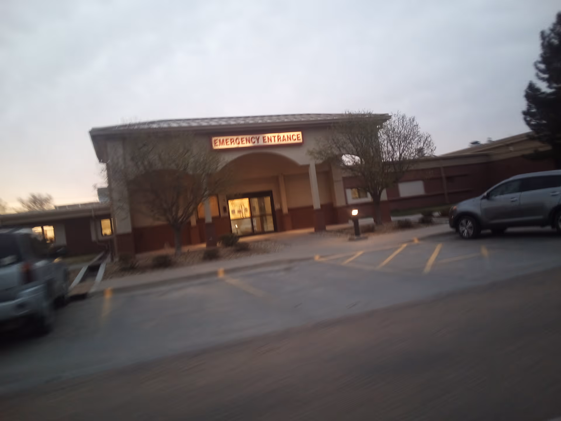 Exterior view of Stevens County Hospital emergency entrance with parked cars in front.