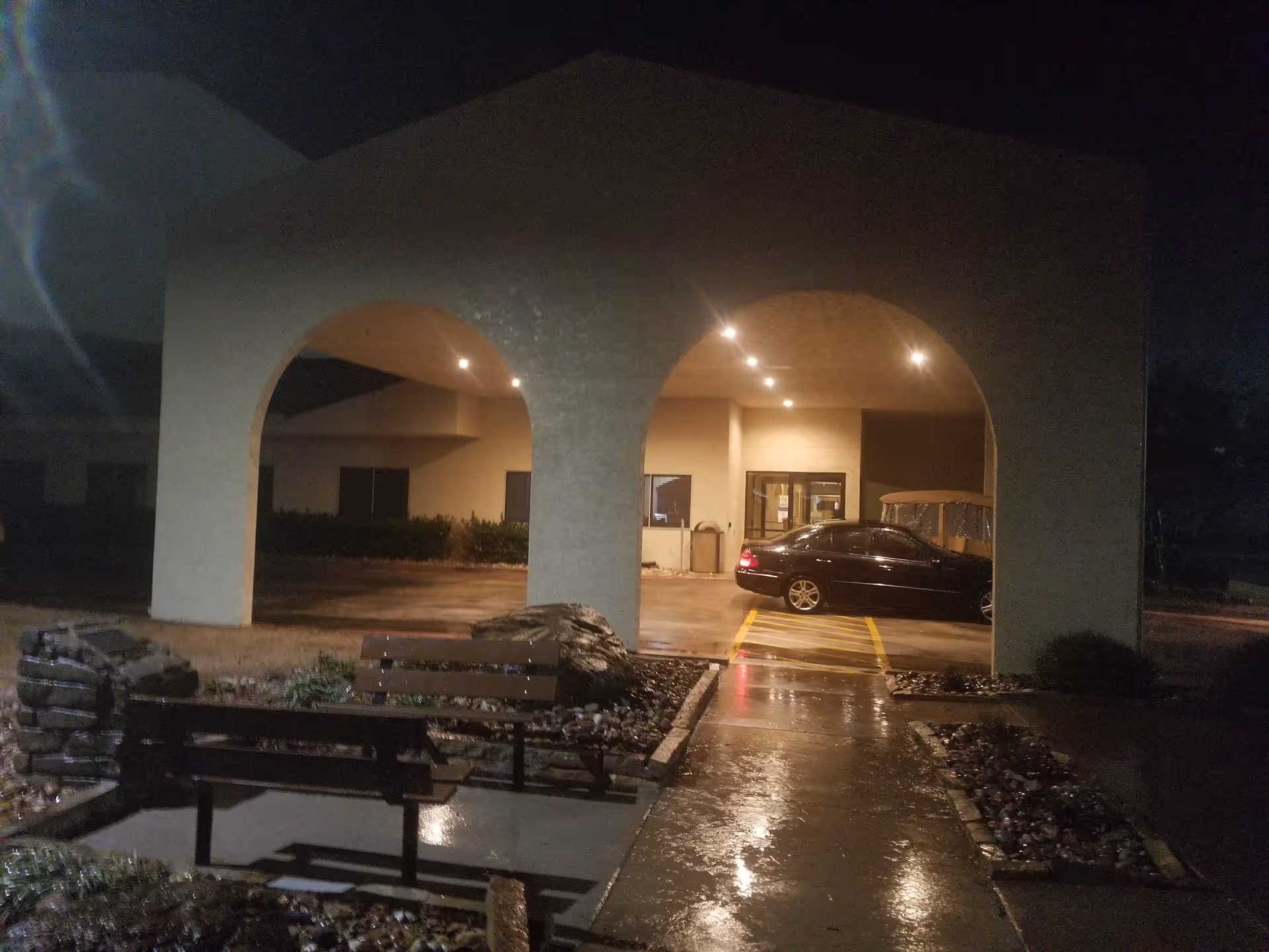 Nighttime view of Good Samaritan Home Health entrance with arches and a parked car.
