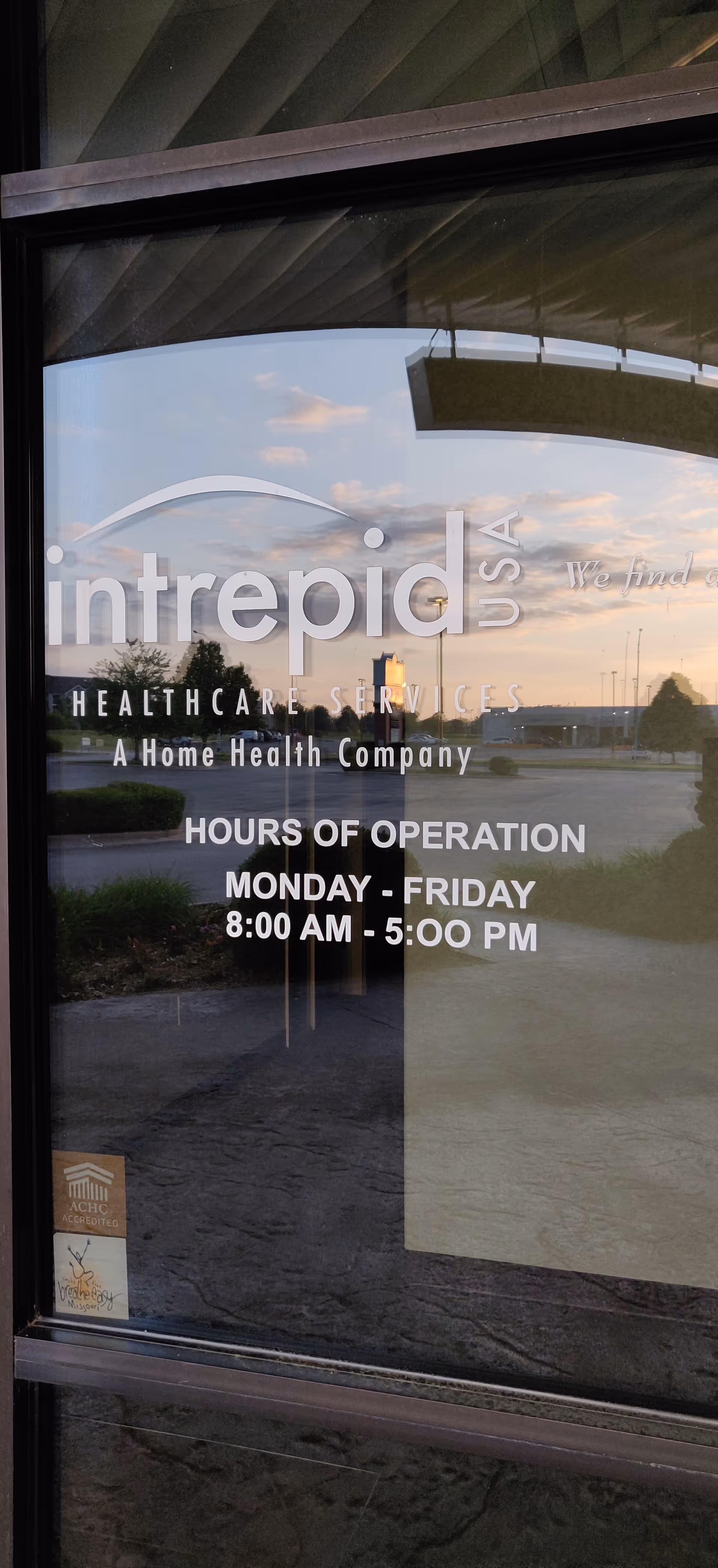 Glass door at facility entrance shows Intrepid USA Healthcare Services logo and hours.