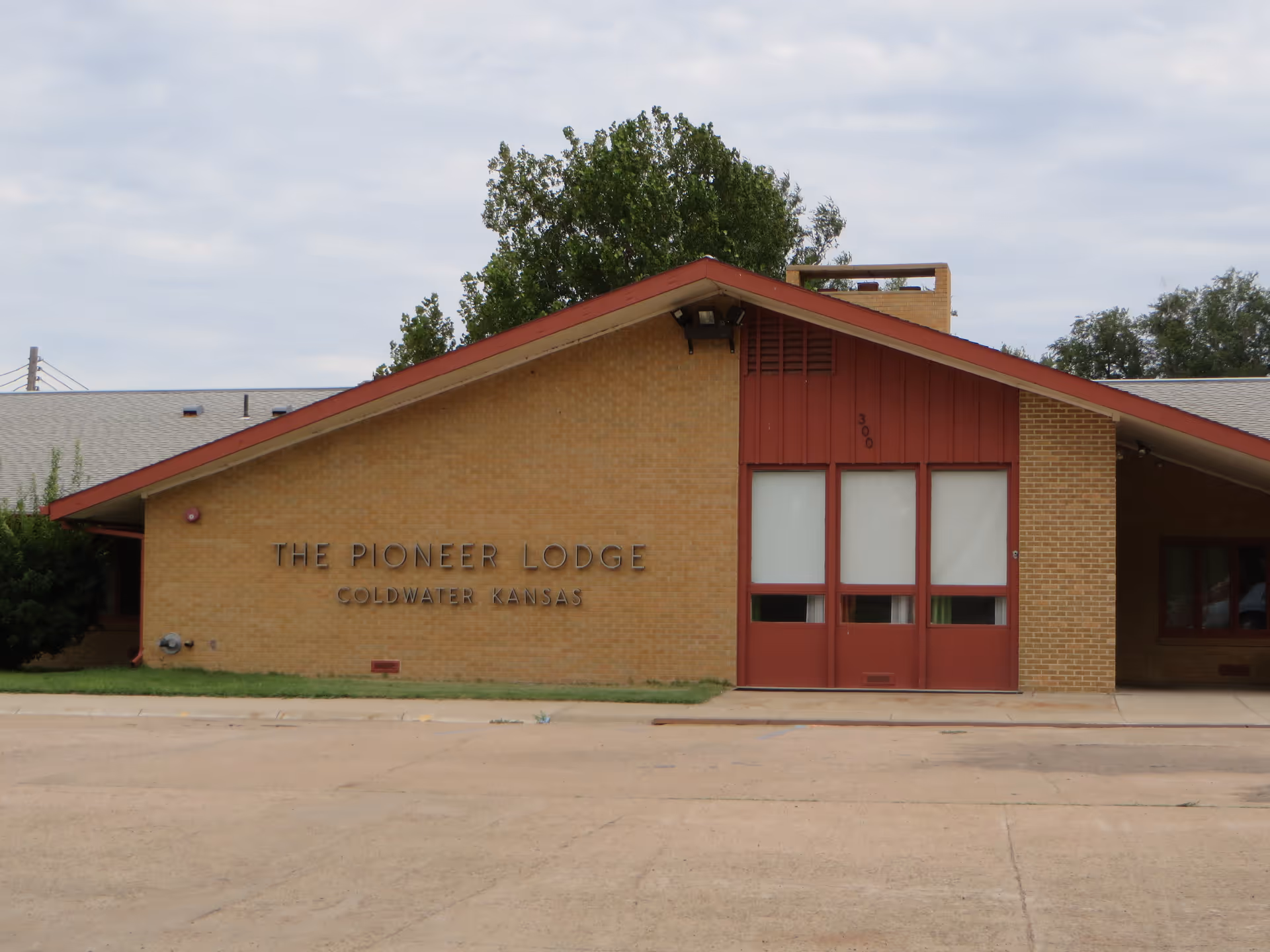 Brick building with red doors and The Pioneer Lodge sign, Goldwater Kansas.