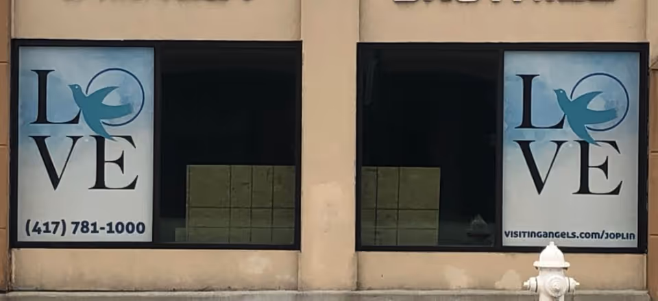 Exterior storefront of Visiting Angels Joplin with large LOVE window signs.