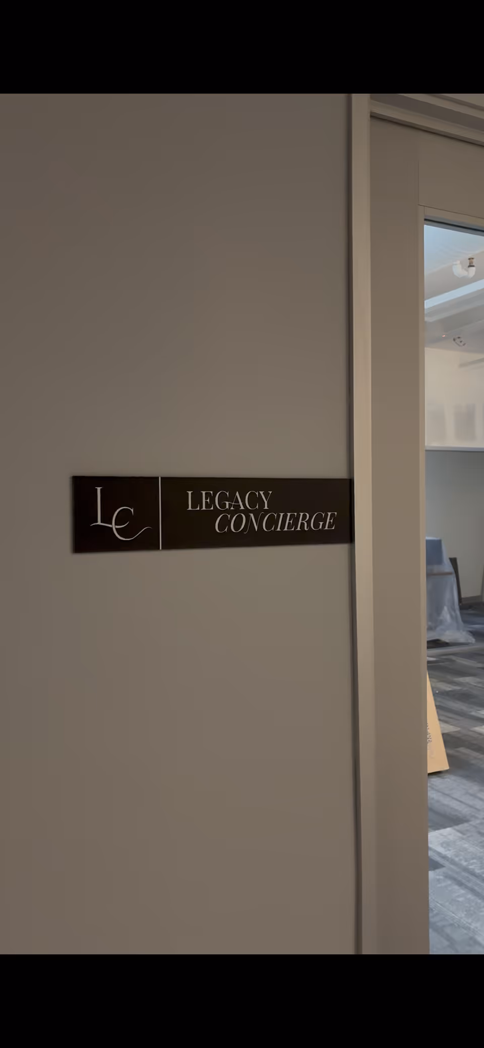 Wall with a Legacy Concierge sign beside an interior doorway in a modern facility.