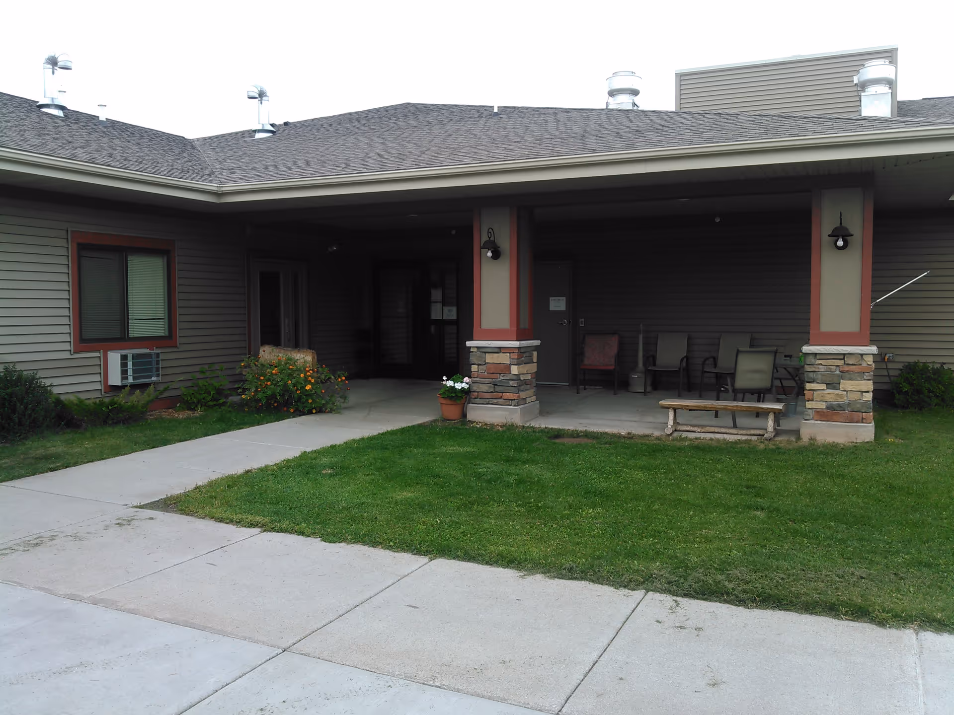 Front entrance of Carefree Living Silver Bay with covered porch and outdoor seating.