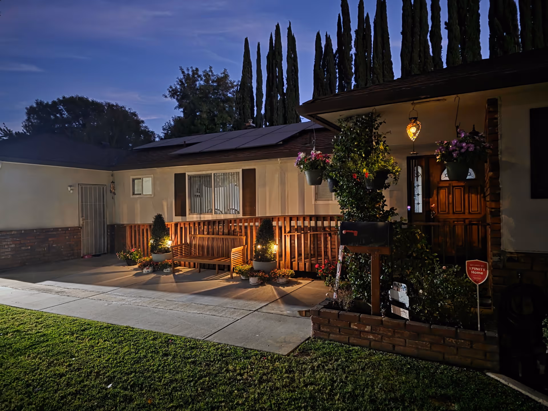 Exterior of Shaomar Residential Care building at dusk with front porch, bench, and hanging plants.