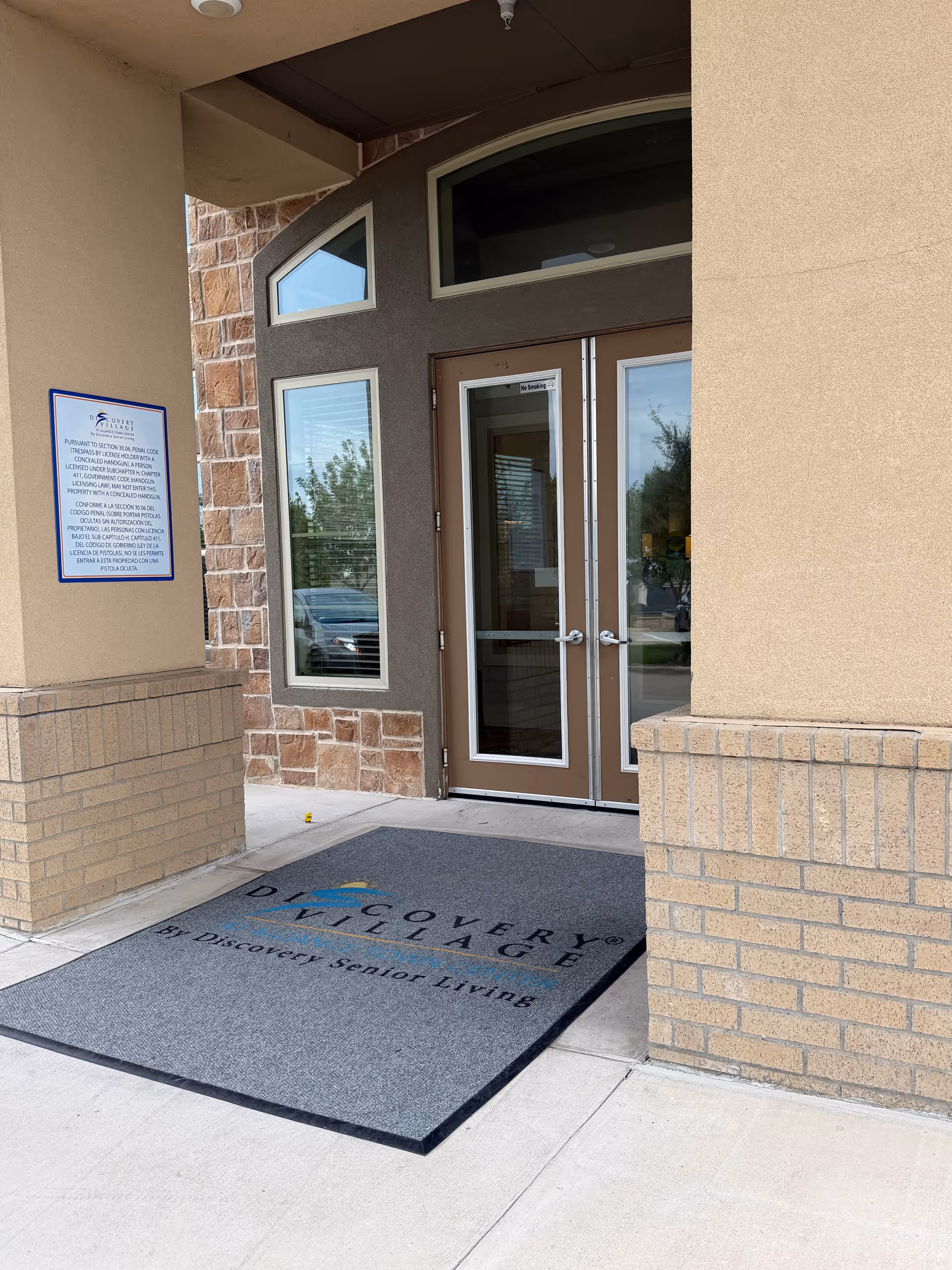Entrance to Discovery Village at Alliance Town Center with glass doors and a welcome mat.