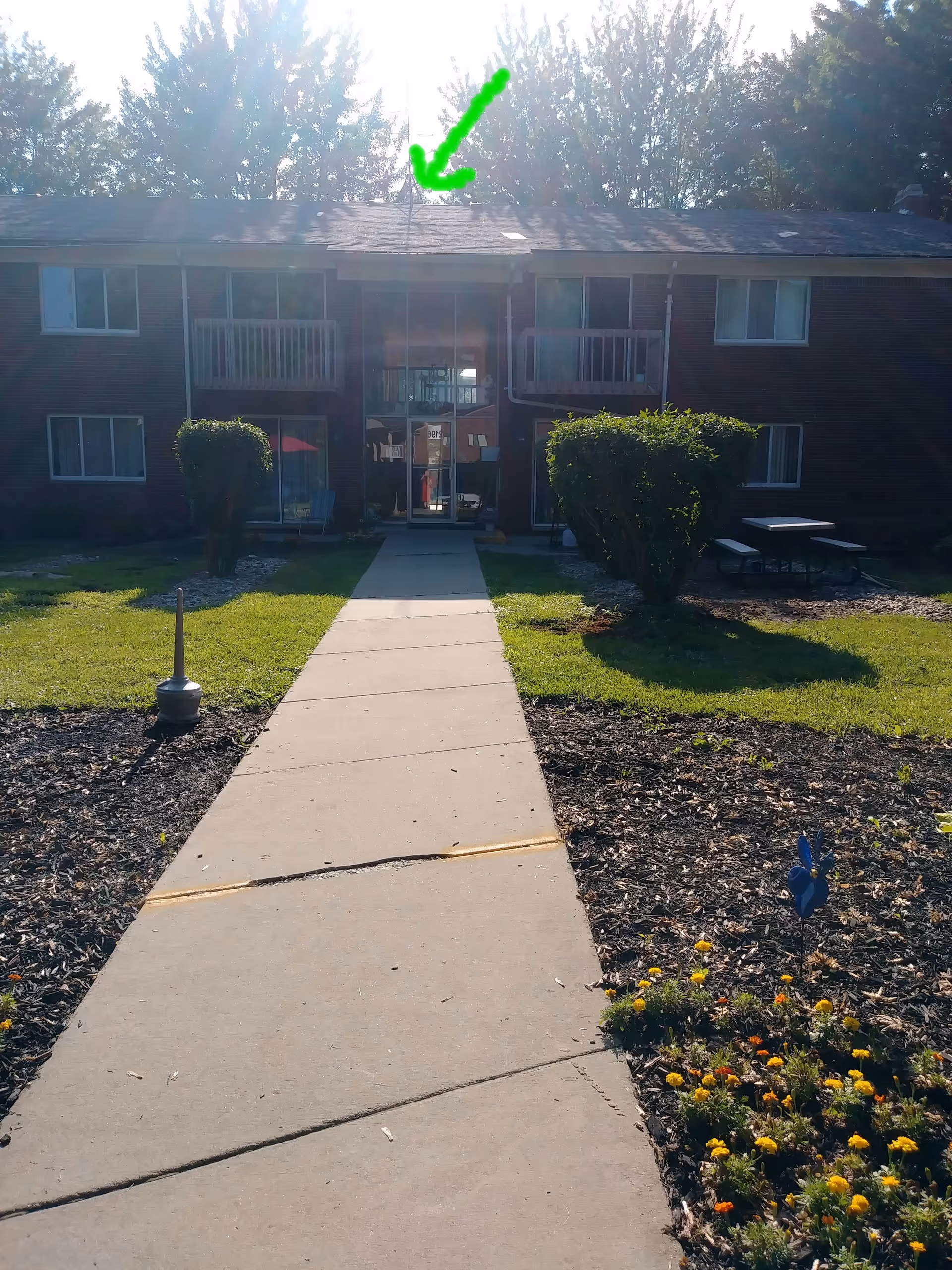 Exterior view of a two-story brick senior living building with a central entrance.