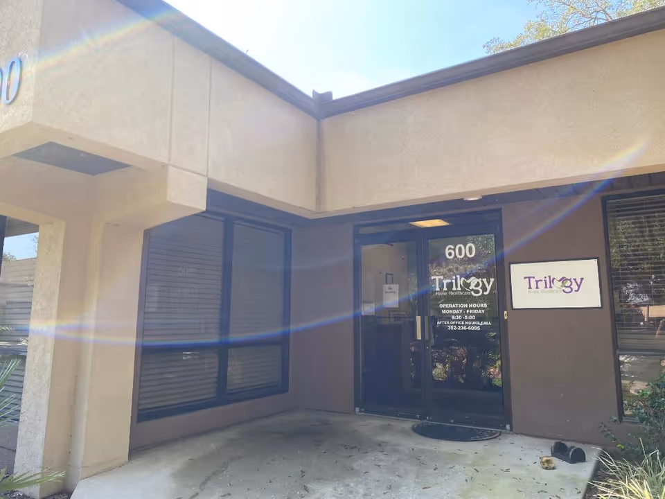 Exterior view of Trilogy Home Healthcare entrance with glass doors and signage