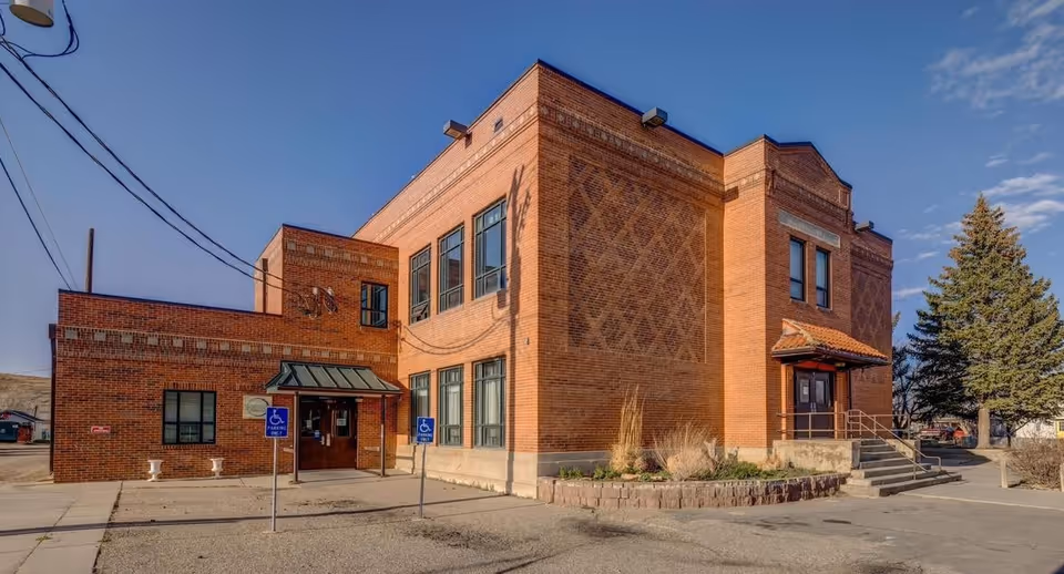 Brick senior living facility exterior with handicap entrance, two-story windows, and steps.