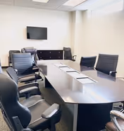 A modern conference room in a senior care facility with a long table and TV.