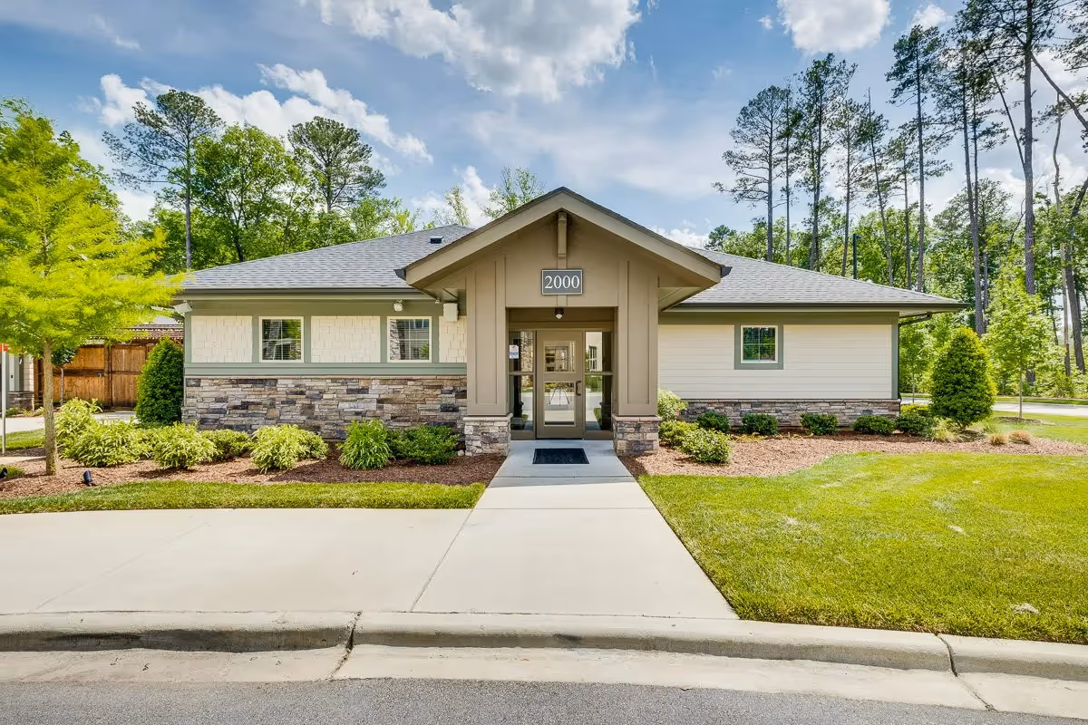 Front view of The Reserve at Mills Farm building with landscaped entrance and trees.