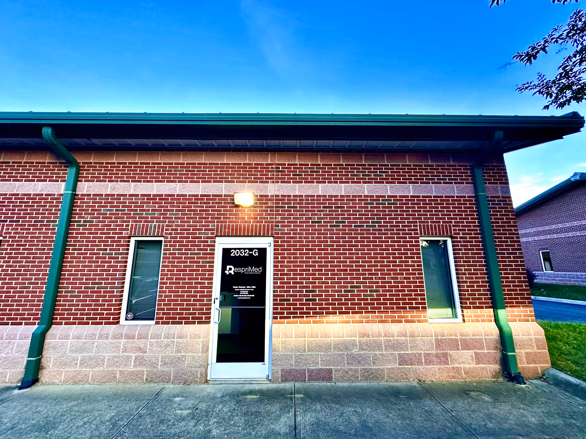 Exterior brick facility with a door labeled RespriMed and green downspouts.
