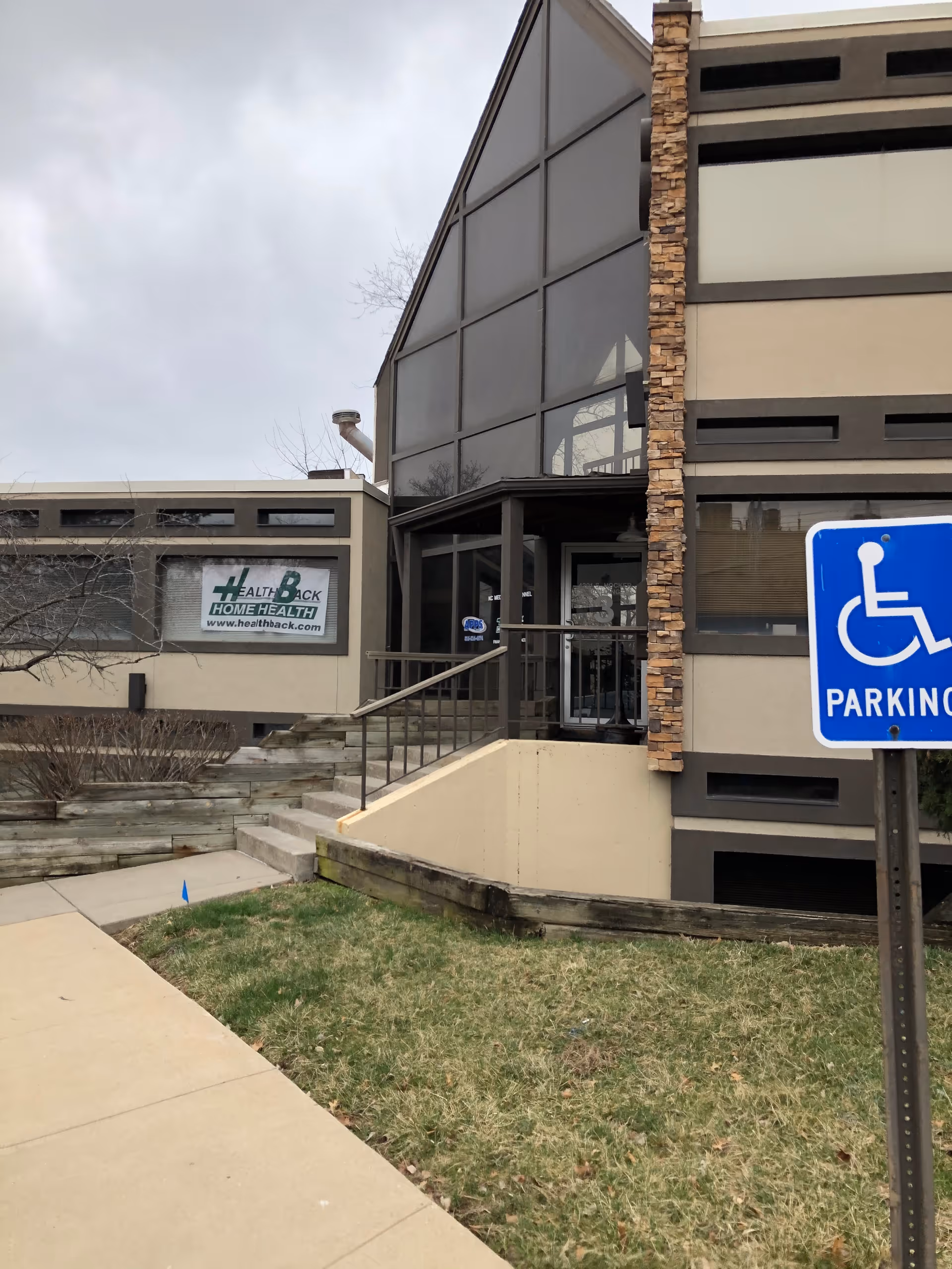Exterior view of a modern senior living facility entrance with glass facade.