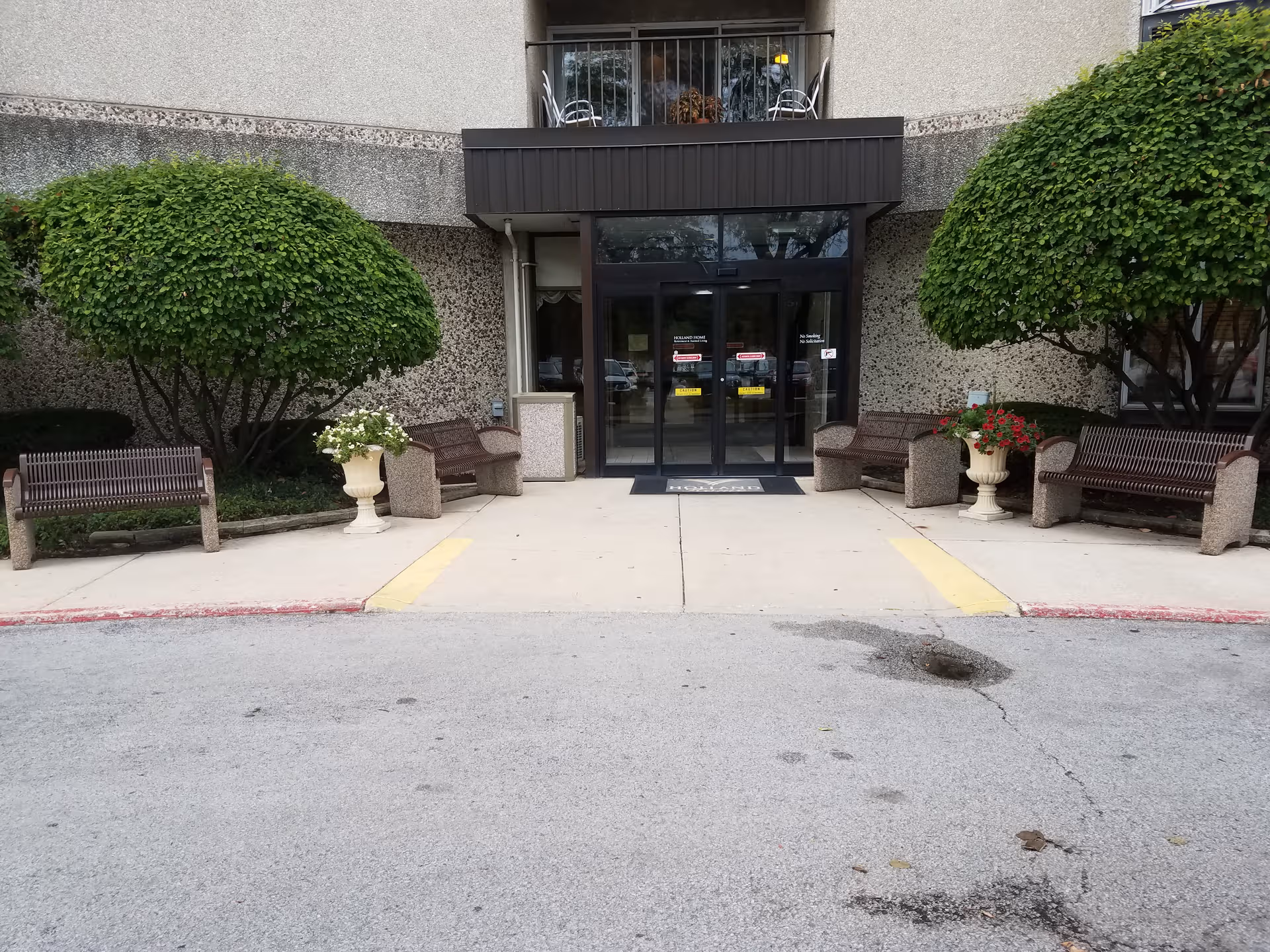 Entrance to Celebrate Senior Living of South Holland with benches and greenery