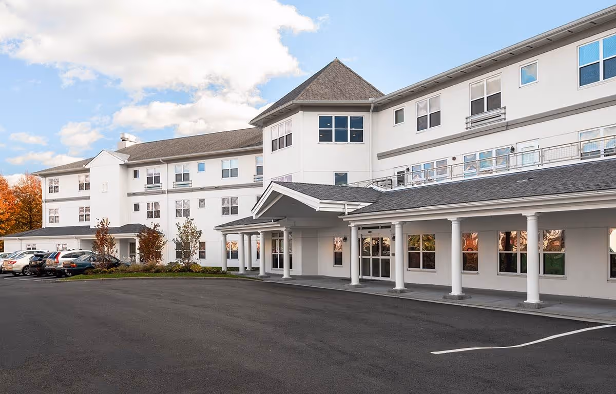 Exterior view of Wingate Residences on the East Side, a white multi-story senior living facility.