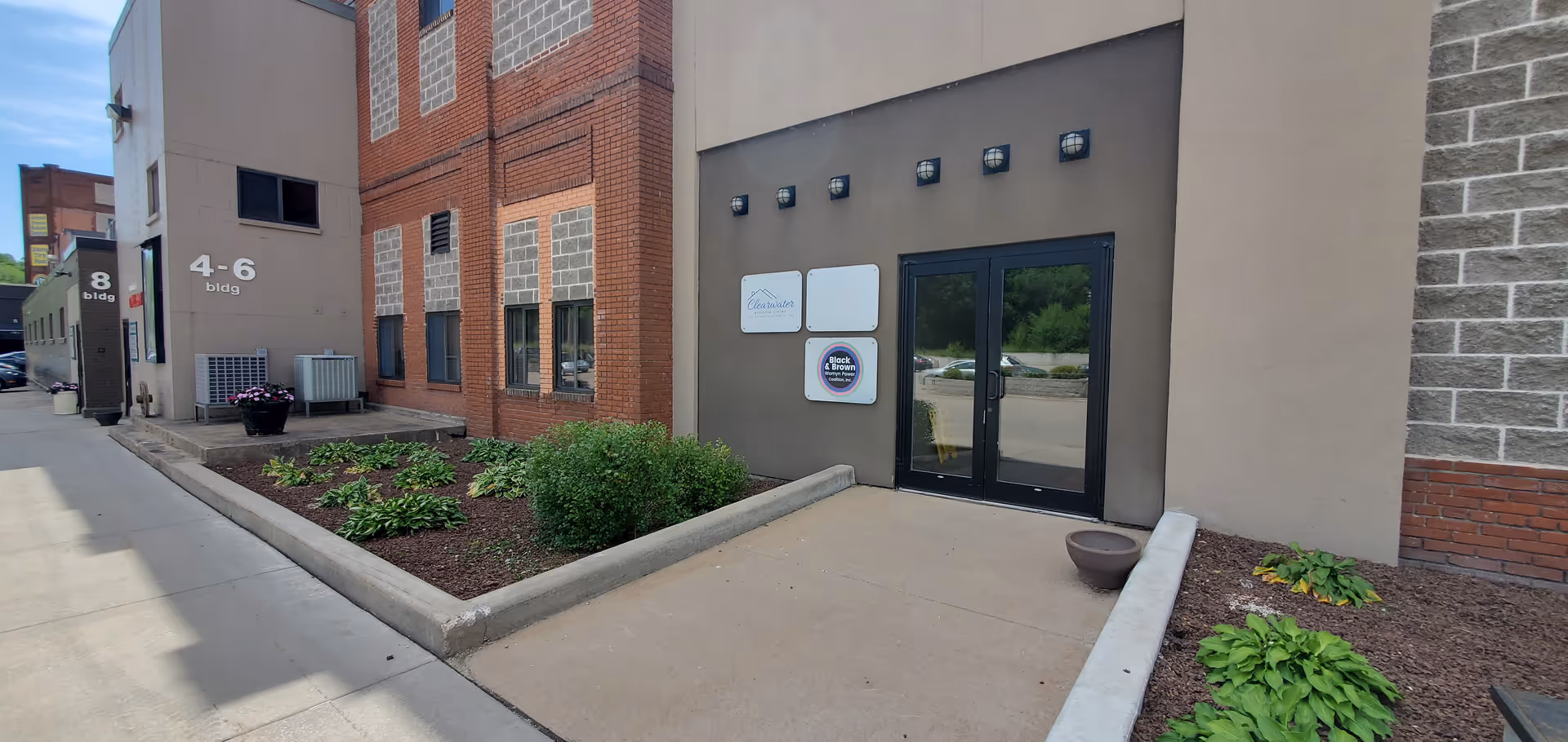 Exterior view of Clearwater Assisted Living entrance with landscaped sidewalk and signage.