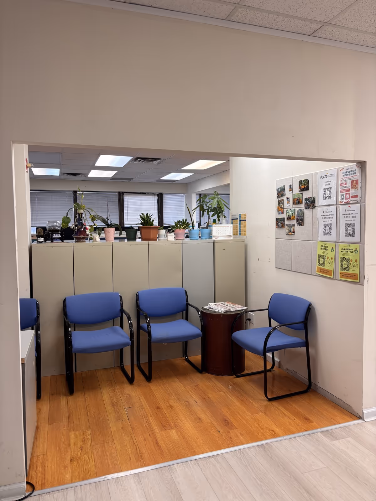 Lobby seating area with blue chairs, cabinets, and bulletin board.