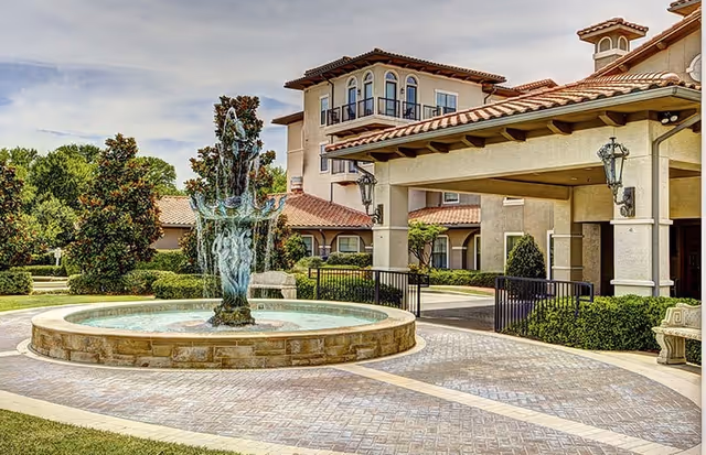 Front entrance of Conservatory at Plano with a circular fountain and landscaped courtyard.