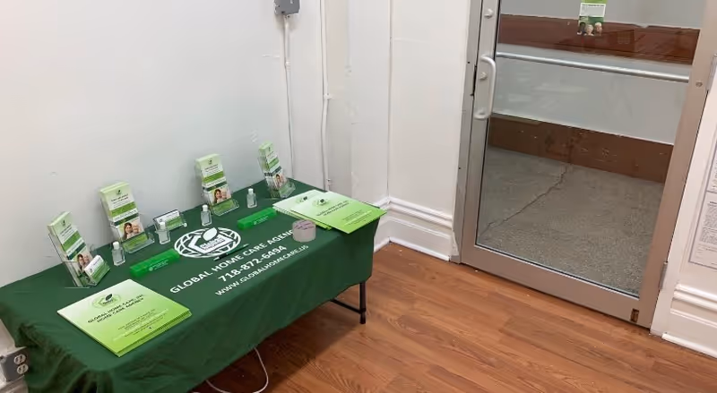 Interior space showing a green-tablecloth table with Global Home Care brochures.