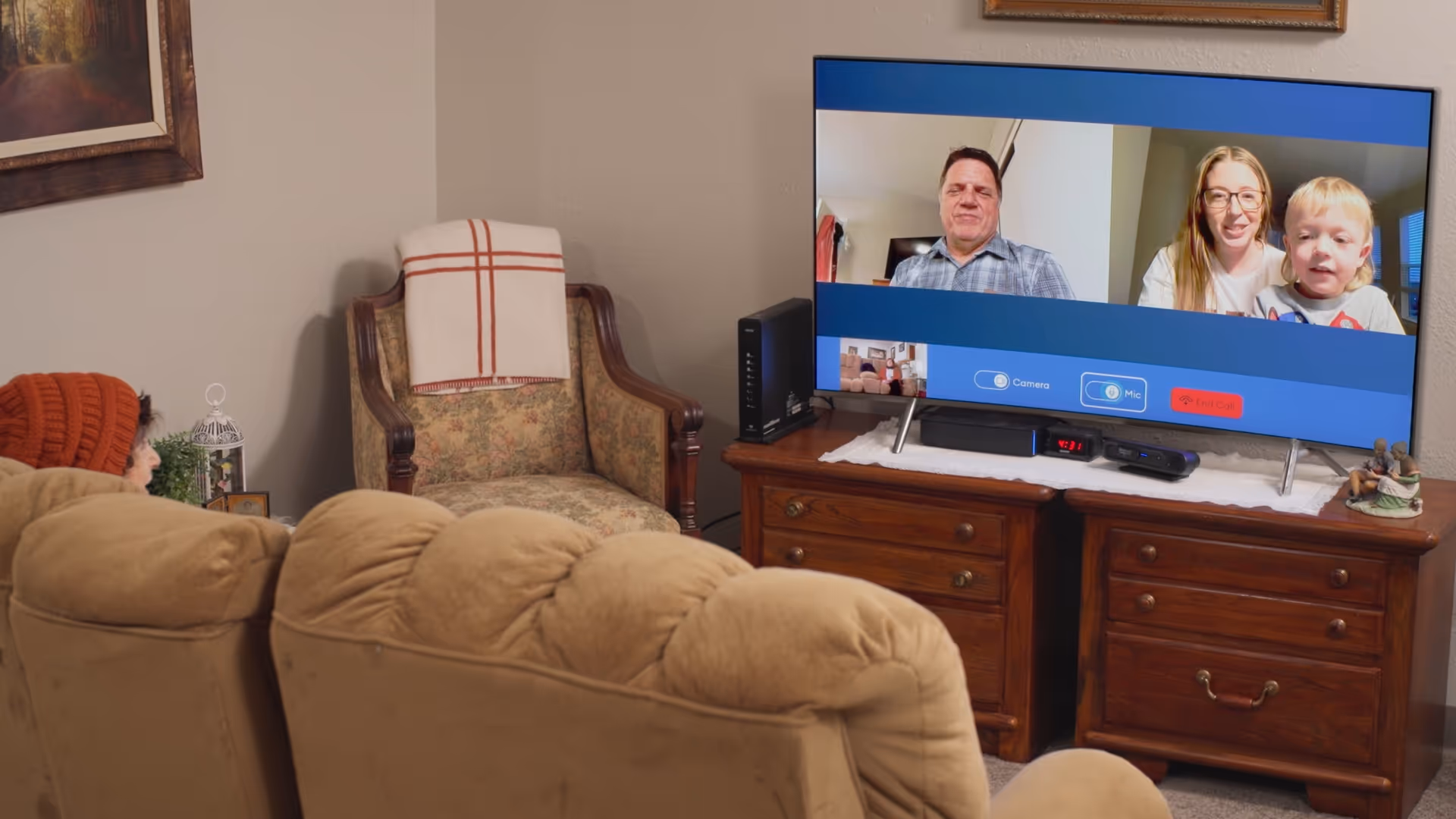 Cozy living room with beige seating and a TV displaying a family video call.