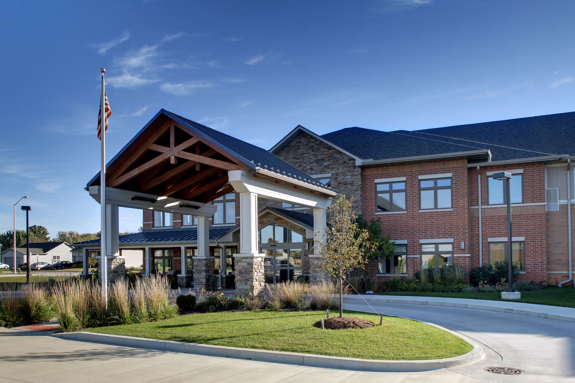 Exterior view of Evergreen Senior Living building with a covered entrance and flagpole.