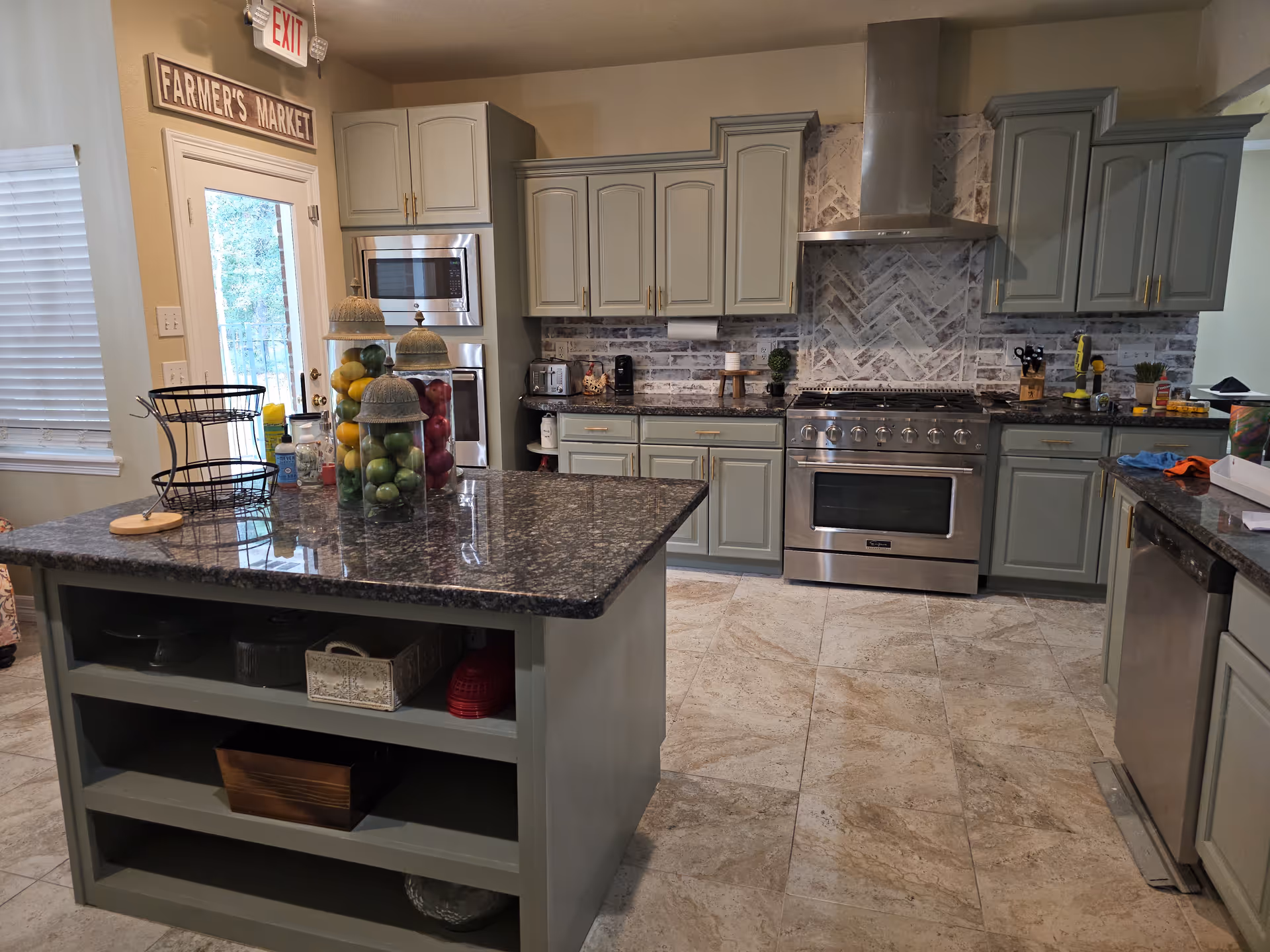 Spacious modern kitchen with gray cabinets, stainless appliances, and a central island.