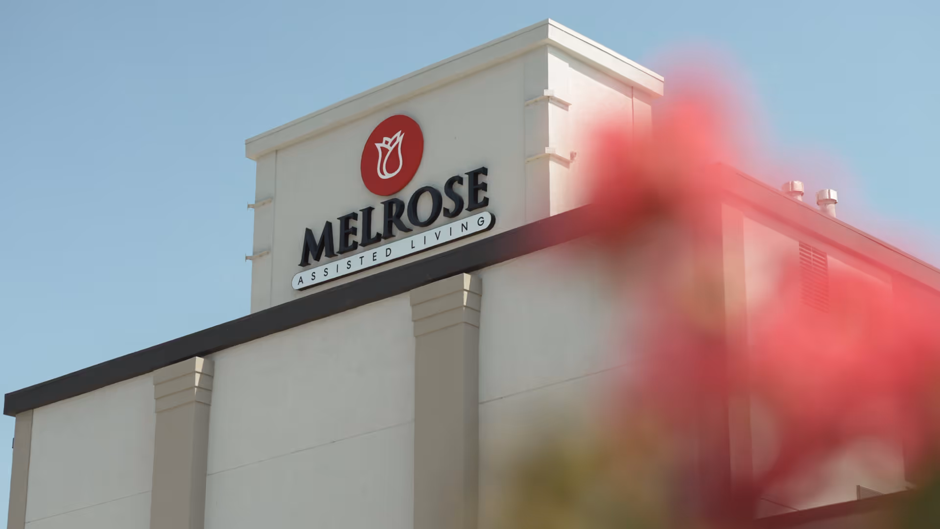 Exterior view of Melrose Assisted Living building with sign on the facade.