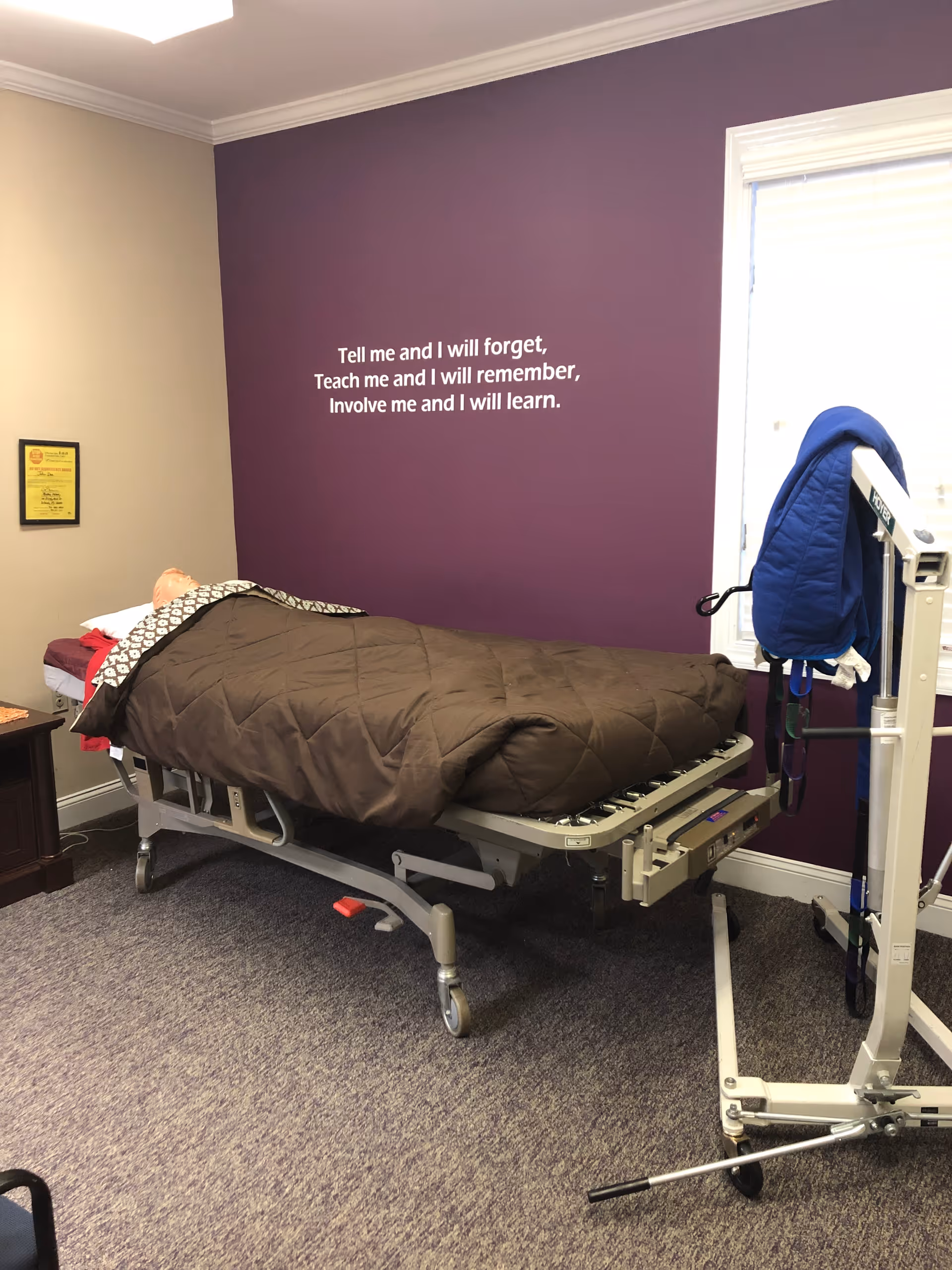 Adjustable hospital-style bed in a furnished bedroom with a purple accent wall.