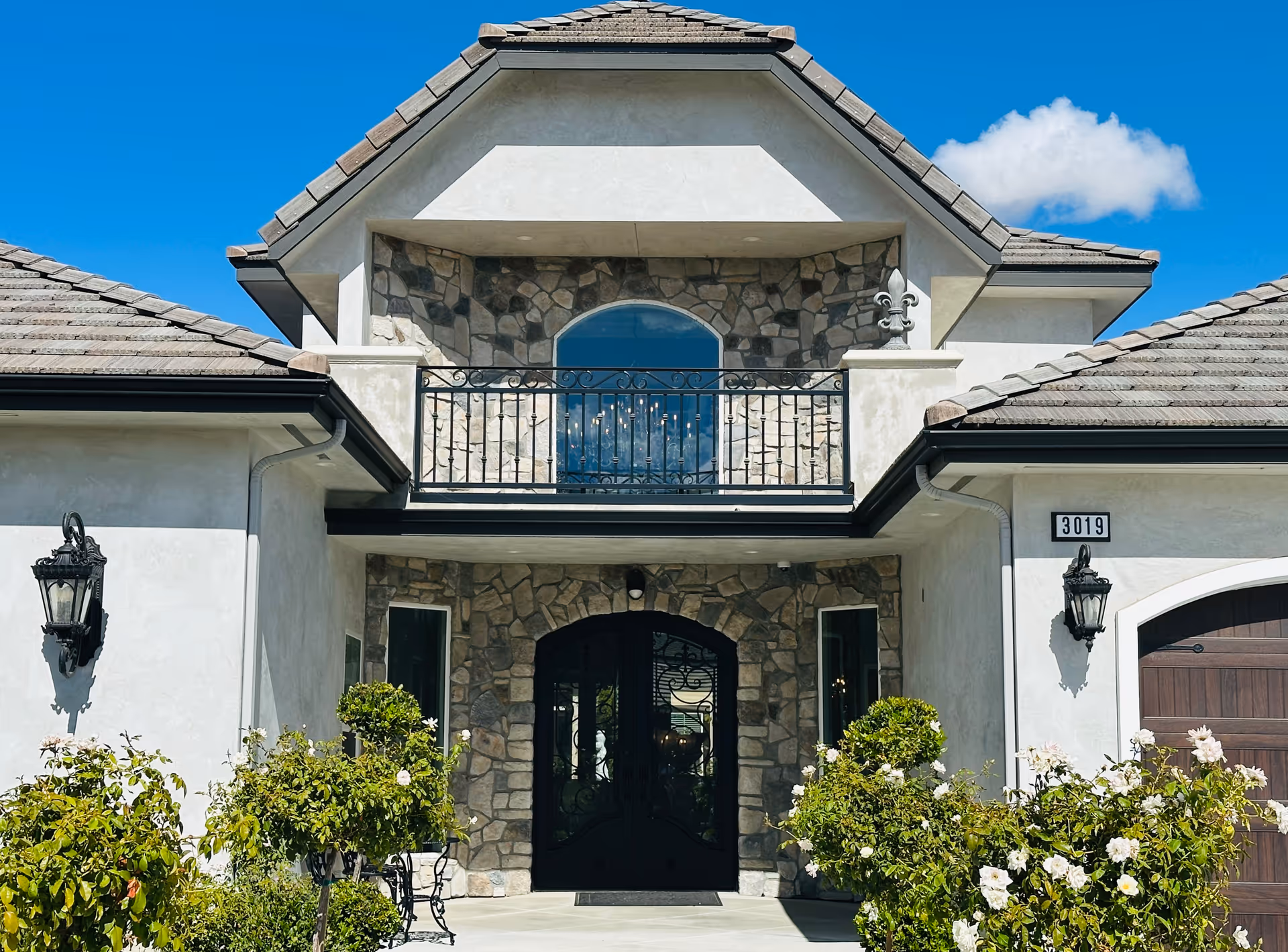 Front view of a residential care facility entrance with stone facade and balcony.