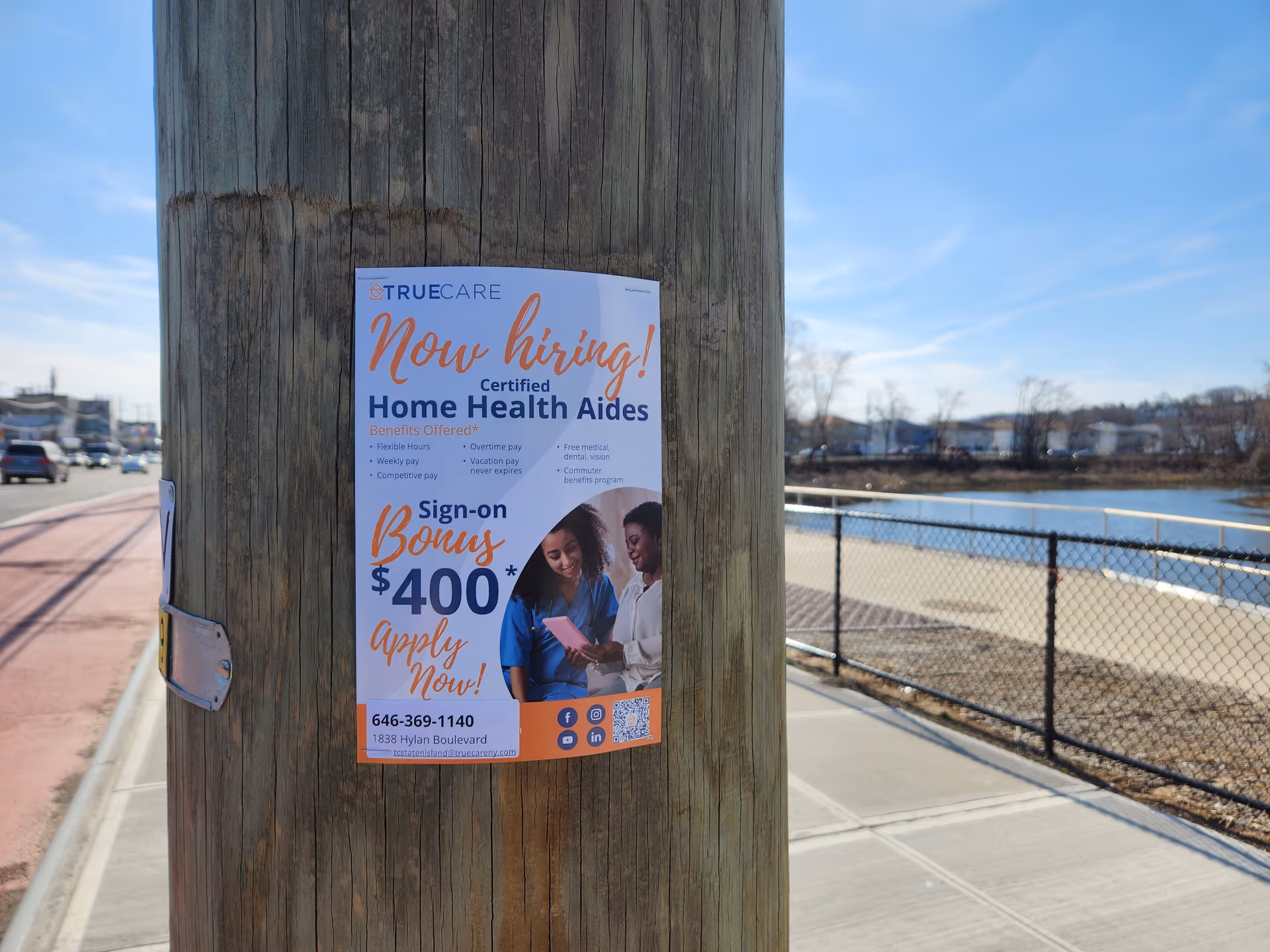 poster on a wooden utility pole advertising home health aide jobs by waterfront.
