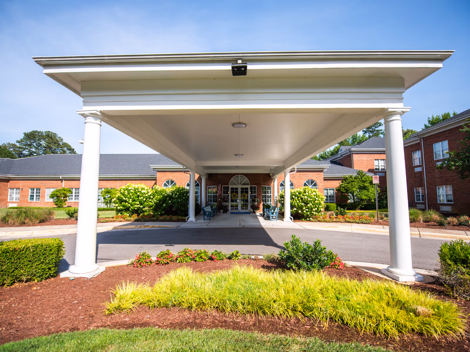 Front entrance of Commonwealth Senior Living at Cedar Manor beneath a white portico with columns.