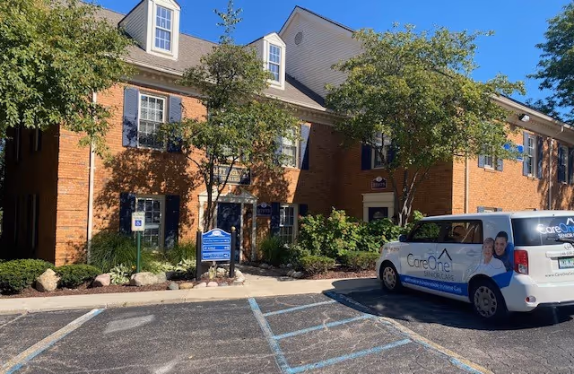 Brick senior care facility exterior with a CareOne van parked in a lot