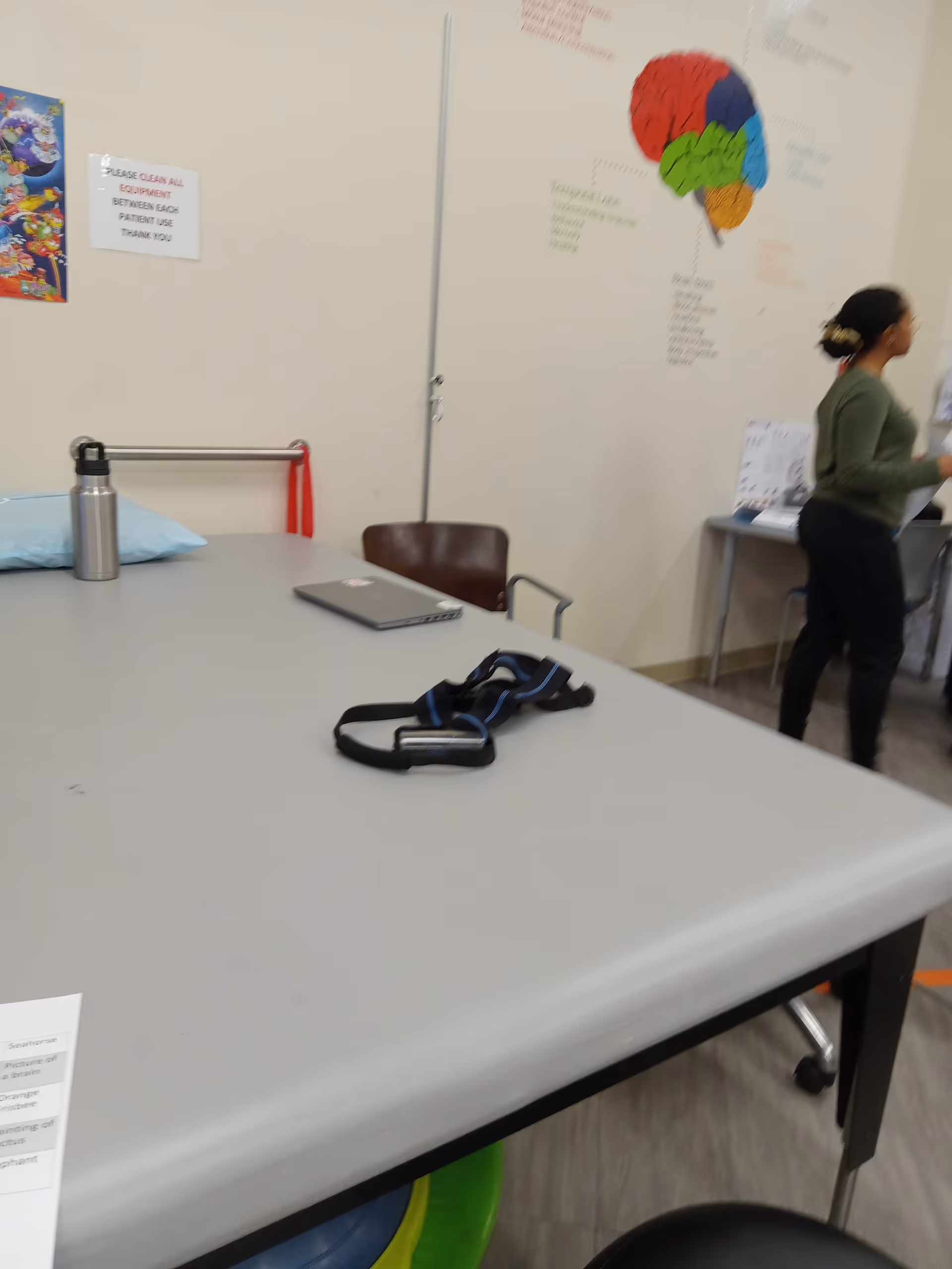 NeuroRestorative interior featuring a large table, medical equipment, and a staff member nearby.