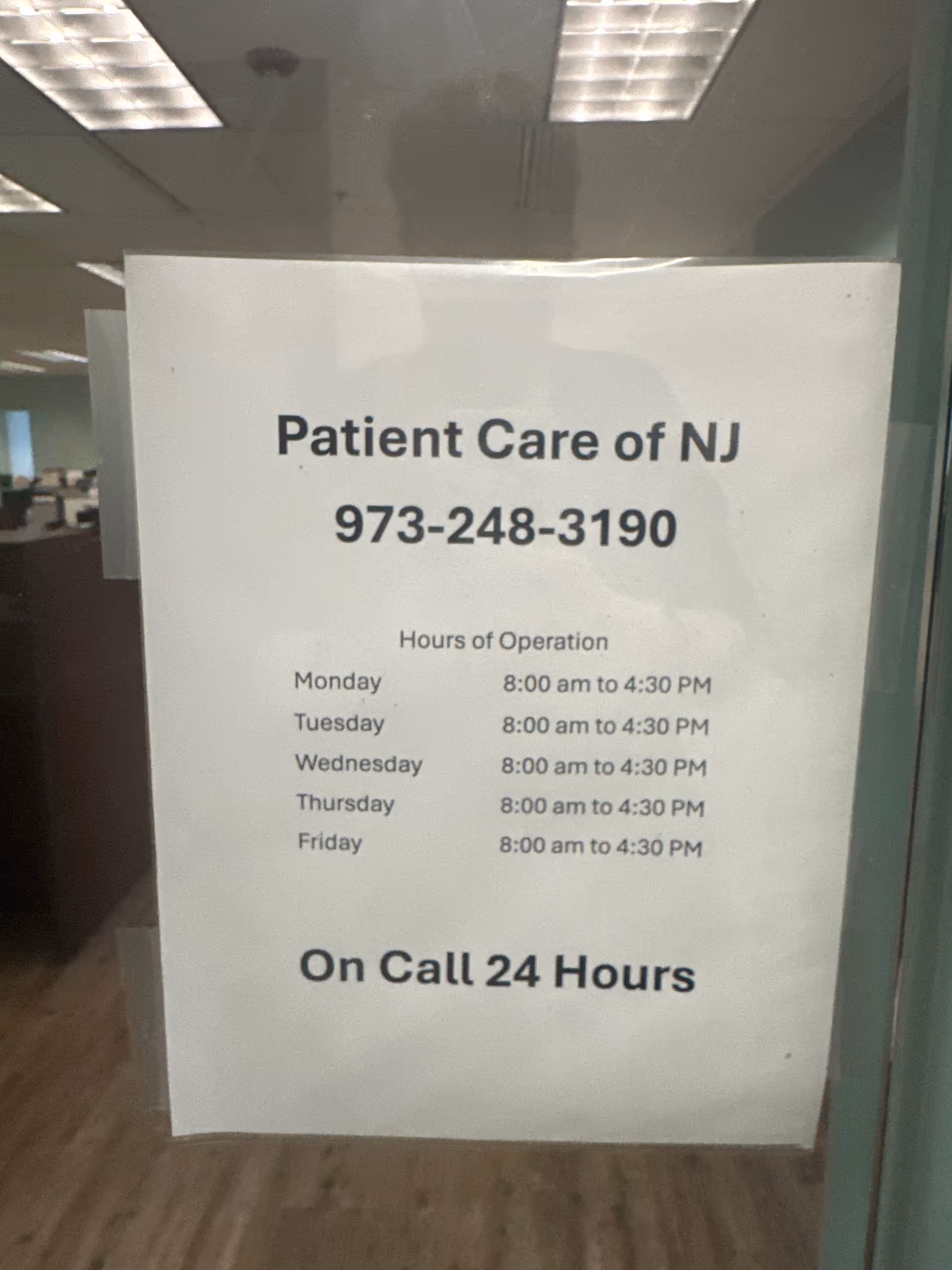 Sign on glass door showing Patient Care of NJ contact and hours of operation.