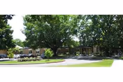 Exterior view of Lebanon Valley Home senior living facility with trees, a curved driveway, and cars.