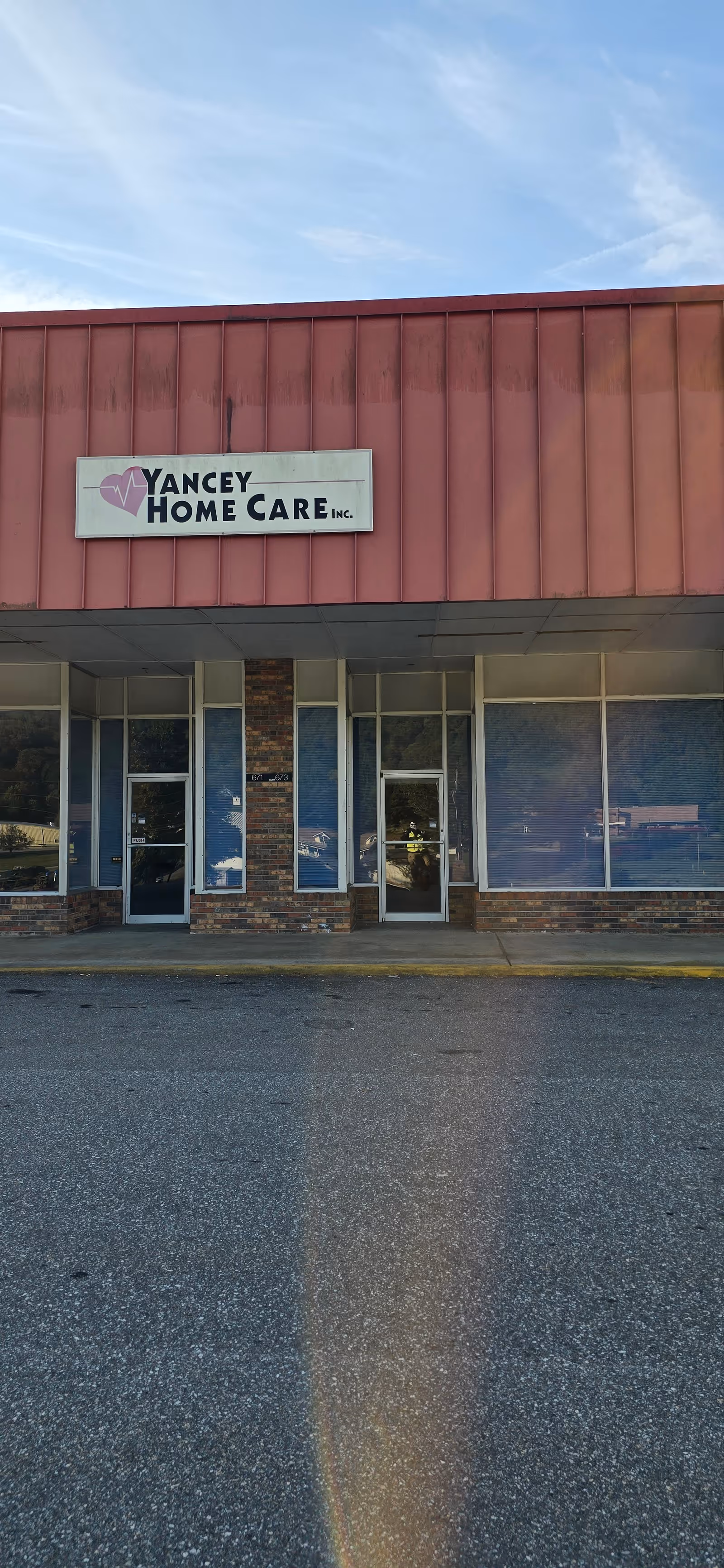 Front view of Yancey Home Care facility entrance with glass doors and sign.