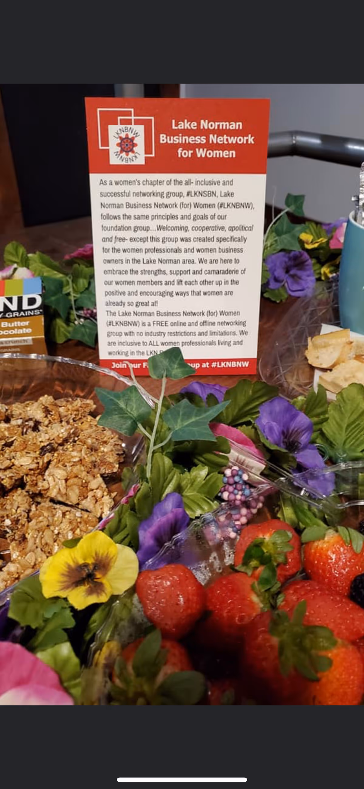 Colorful fruit display with a red sign for Lake Norman Business Network for Women.