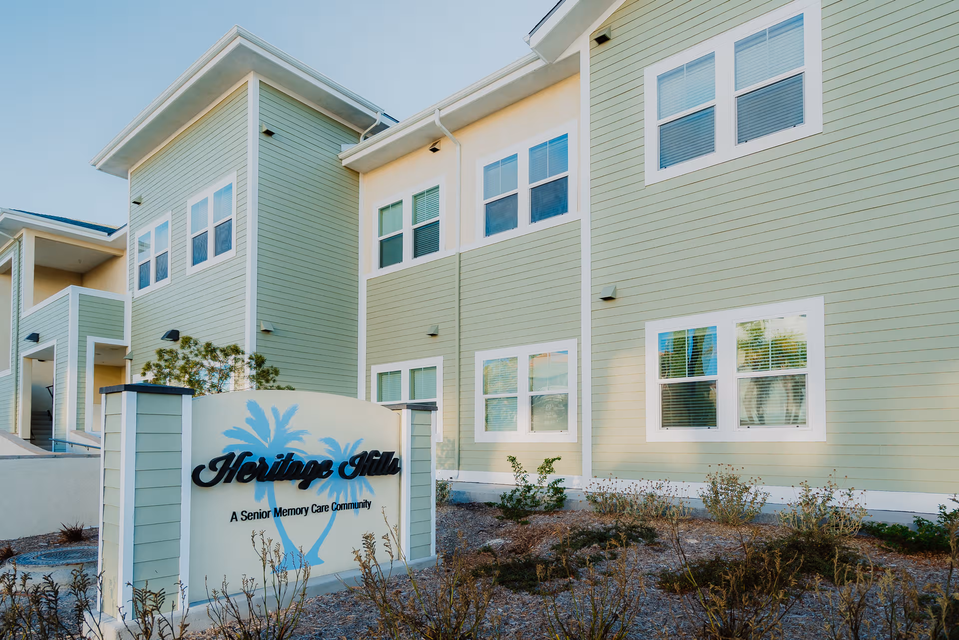 Green, multi-story senior living facility with a Heritage Hills sign and front landscaping.