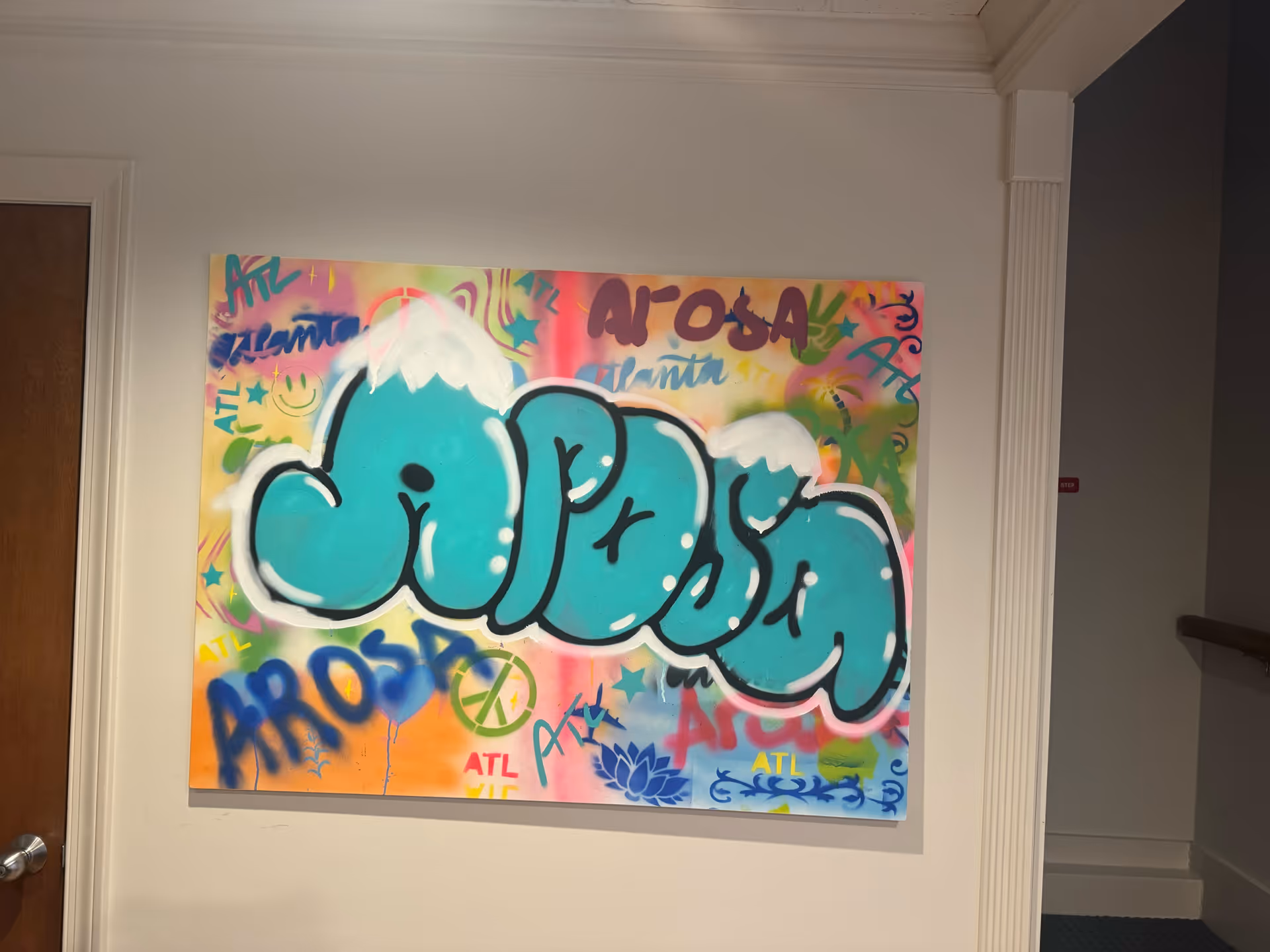 Colorful graffiti mural on a wall in a hallway of Arosa Atlanta senior facility.