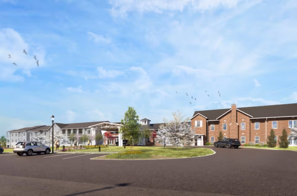 Exterior view of The Claiborne at Newnan Lakes building with brick facade, entrance, and parking.