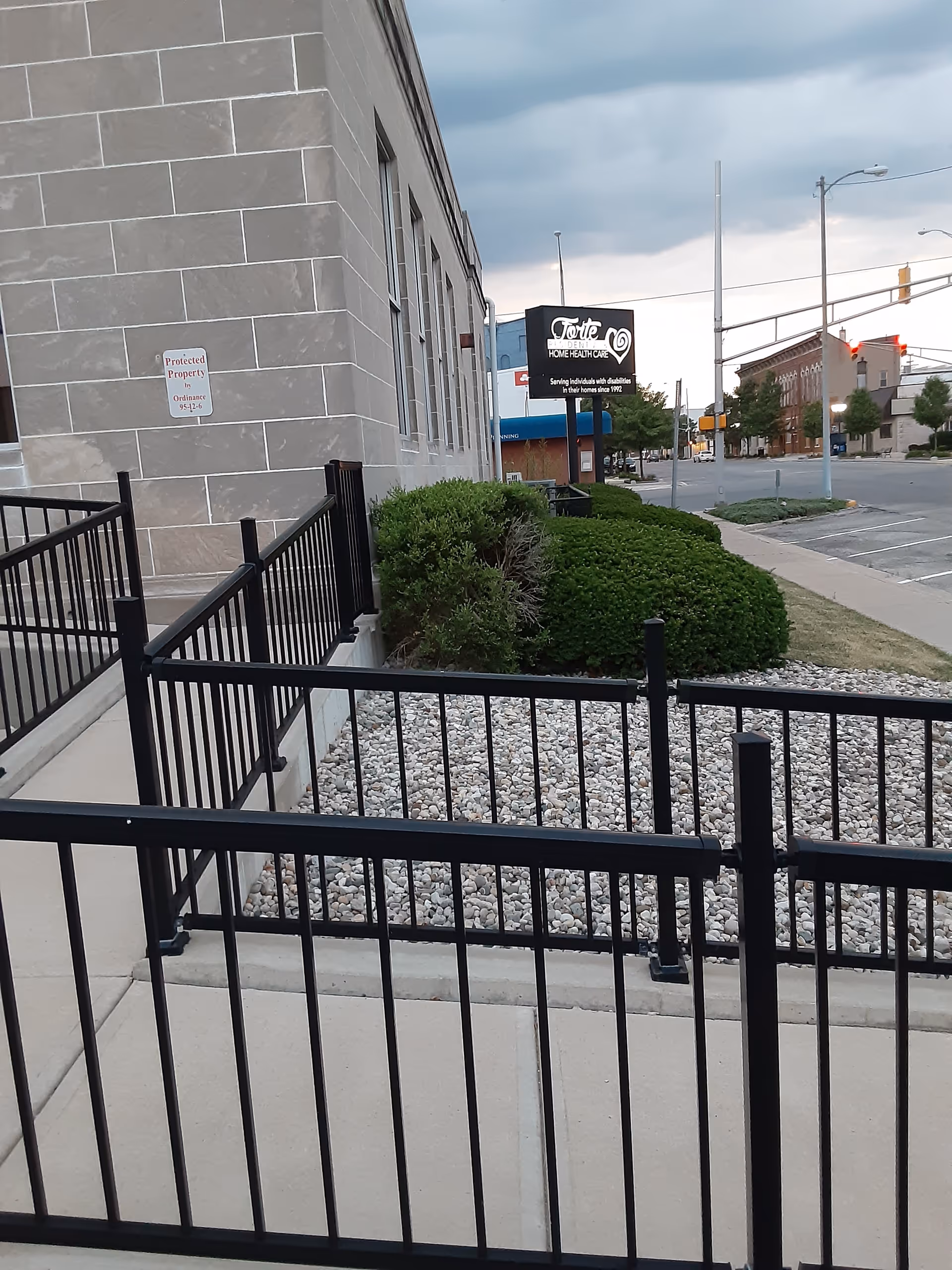Exterior view of Forte Residential building with black railings, gravel landscaping, and a street sign.