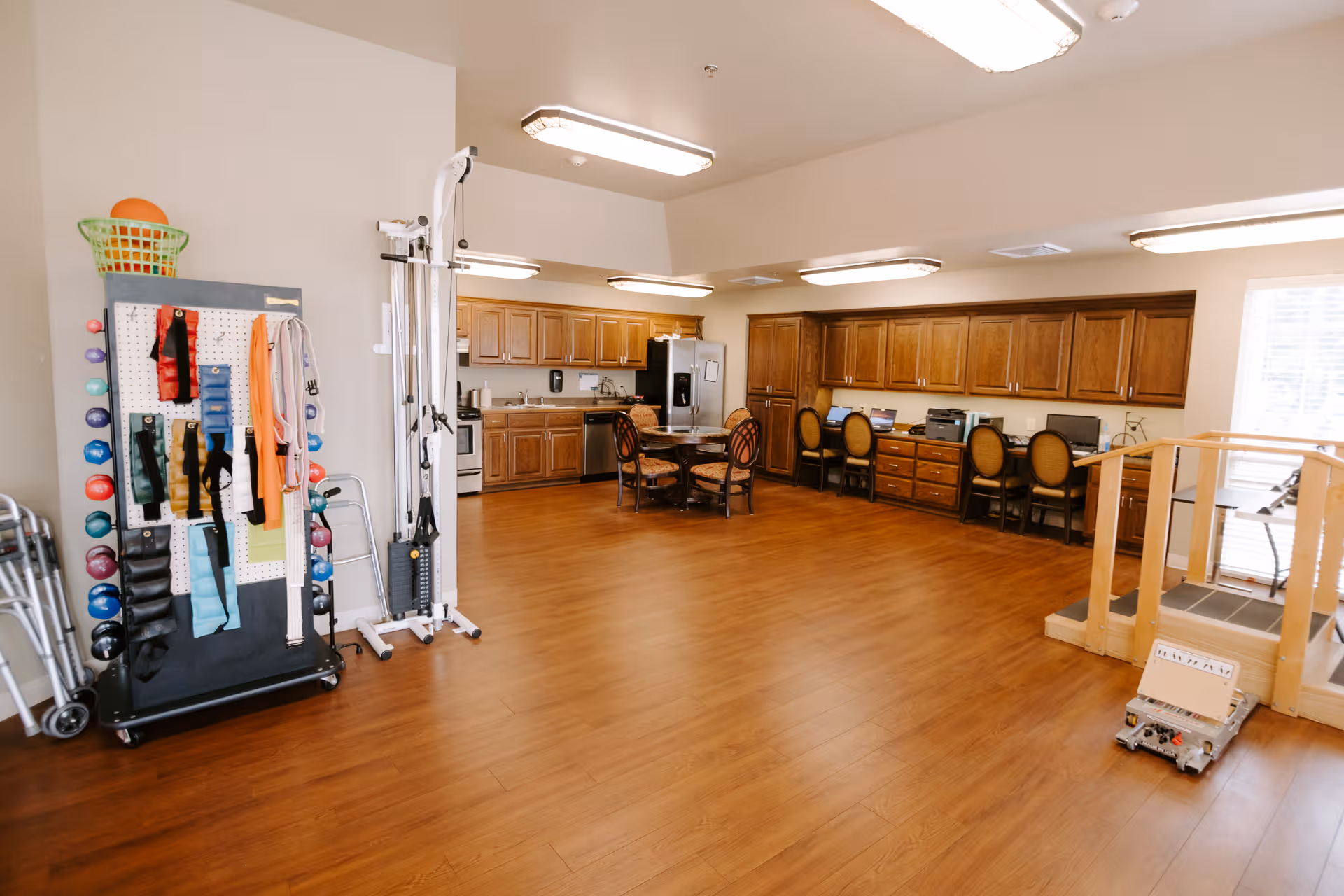 Interior common area with exercise equipment, a kitchenette, and seating along wall.